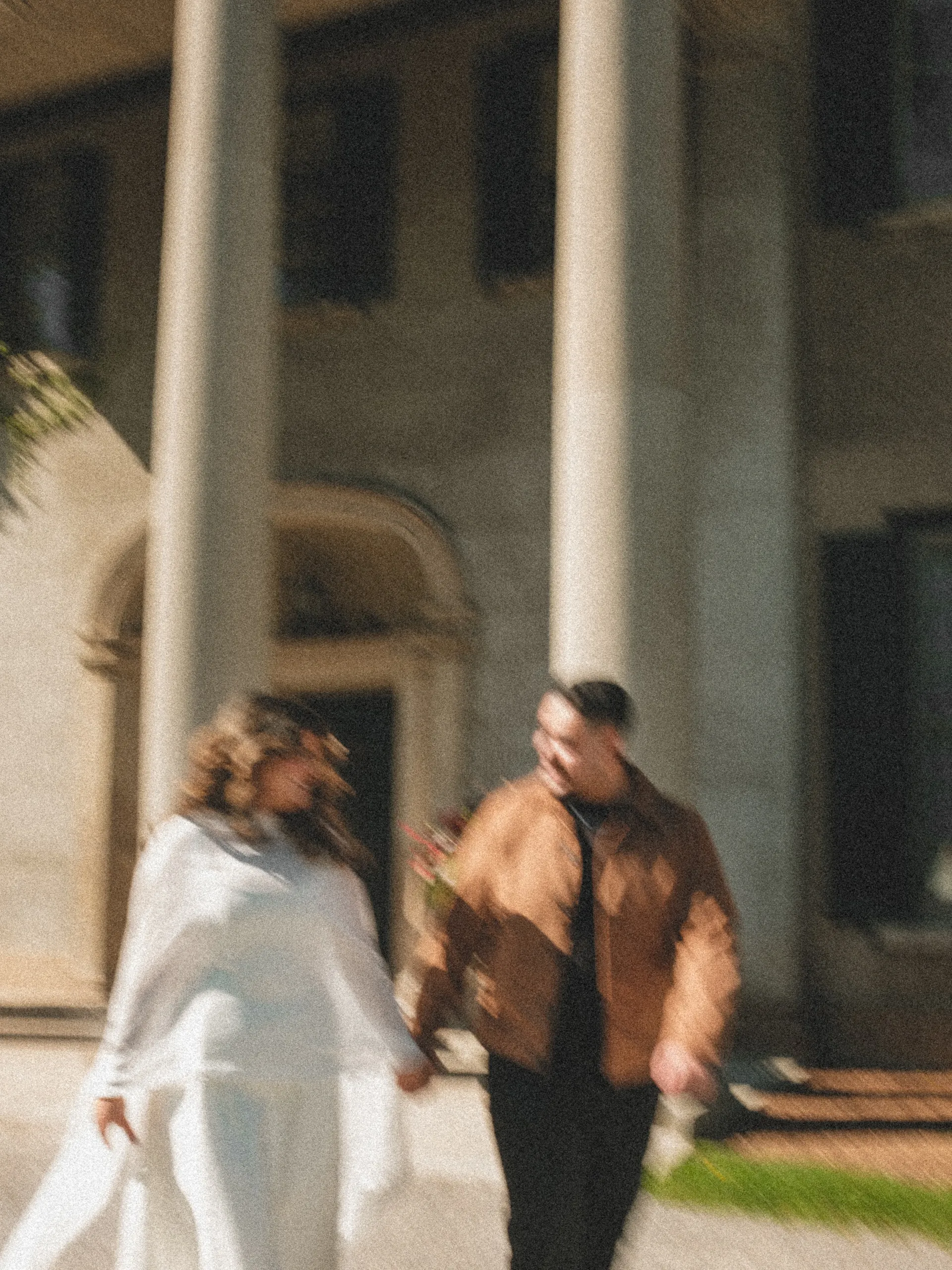 Slow shutter blur of Maninder and Parneet walking hand in hand past the colonnade at Parkwood Estate, by AD Photography