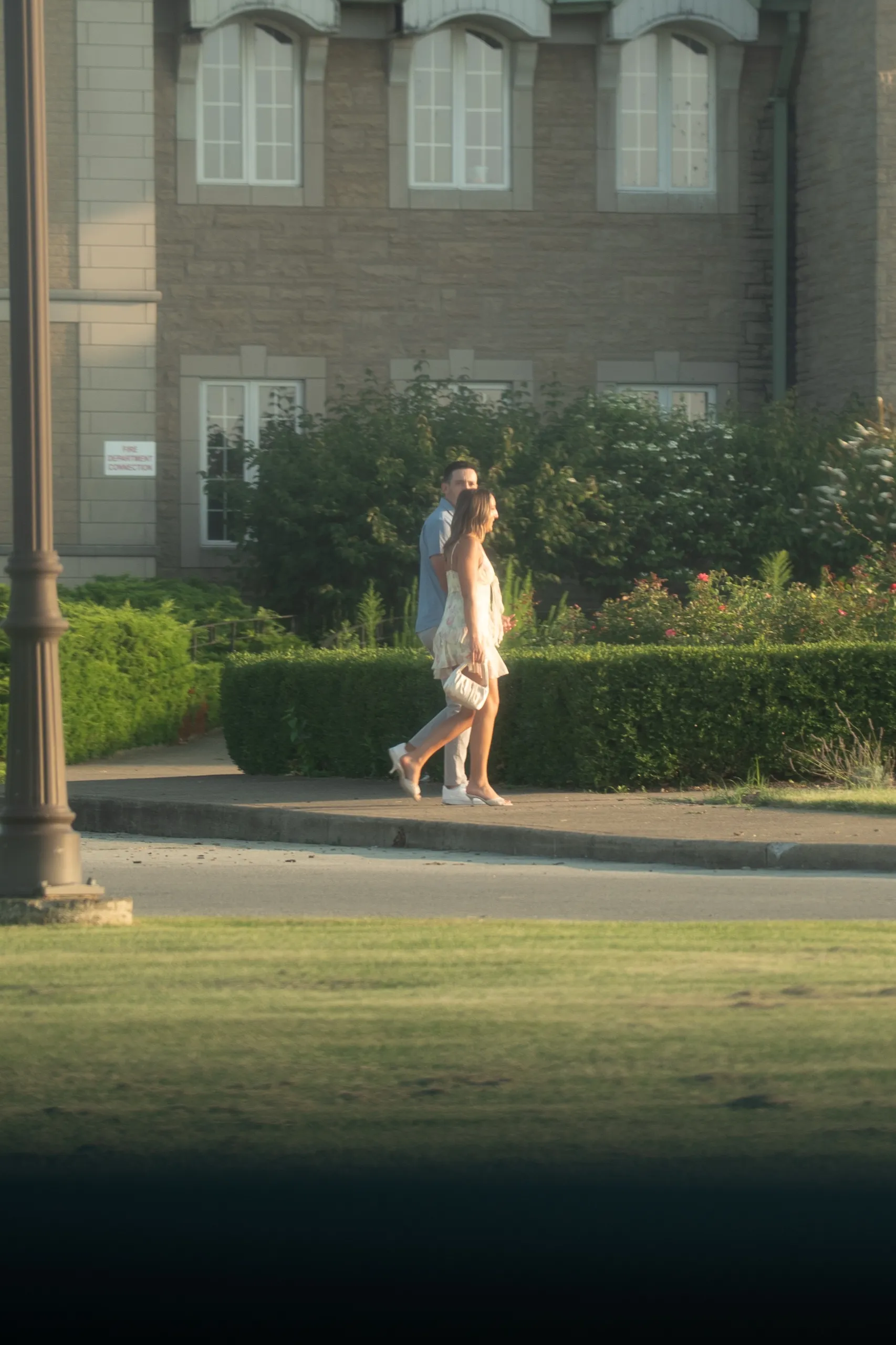 Ashley and Donald walking the estate path, photographed from across the lawn before the proposal, by AD Photography
