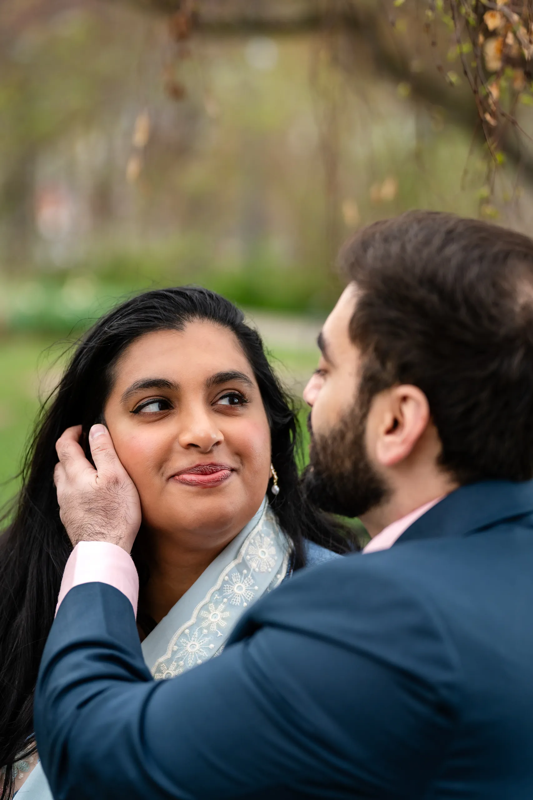 Nadia cradles Abdullah's face in a soft focus portrait beneath the willows at Toronto Music Garden, by AD Photography