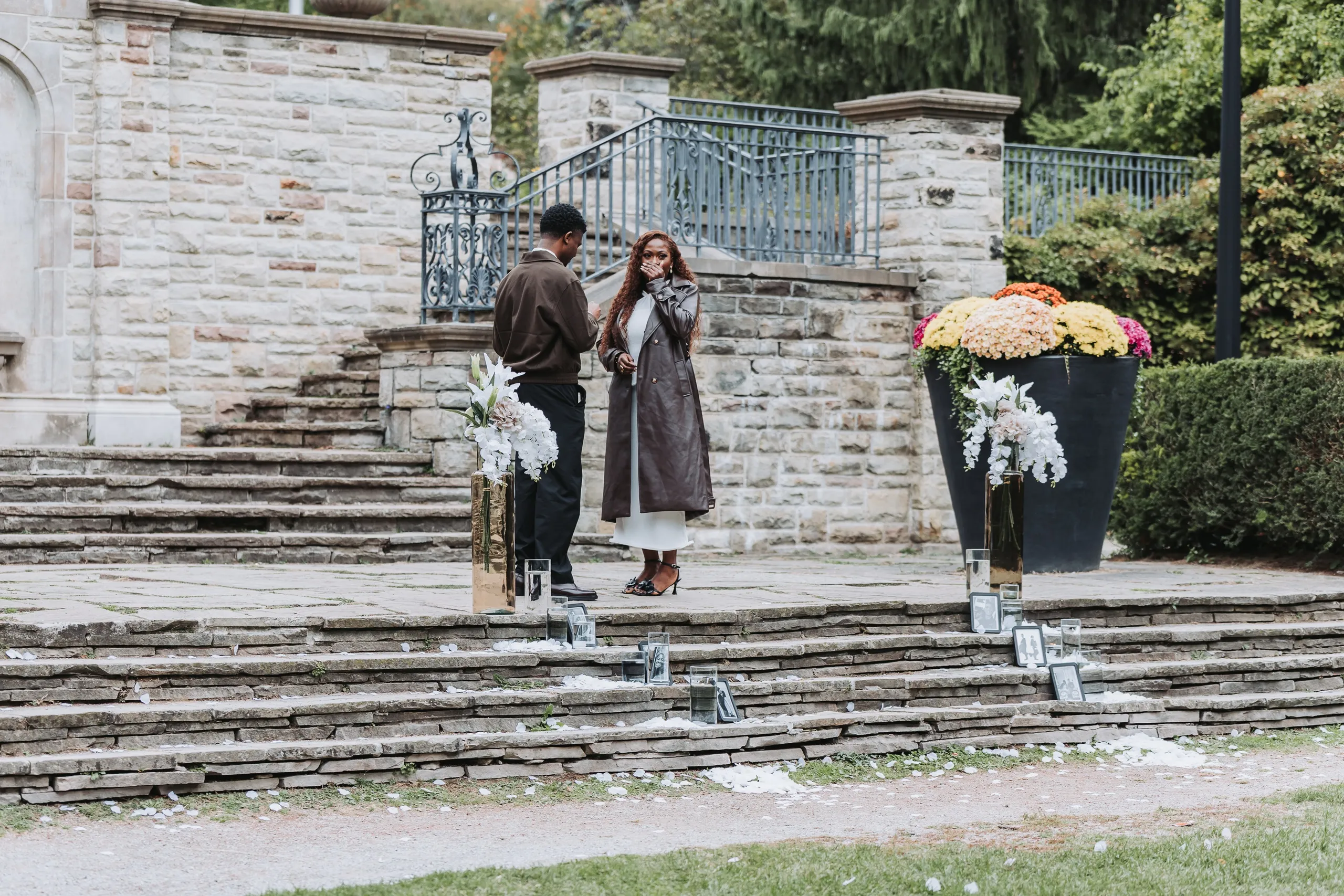 Aimee with both hands over her mouth as she realises what is happening on the stone steps at Alexander Muir Memorial Gardens, by AD Photography
