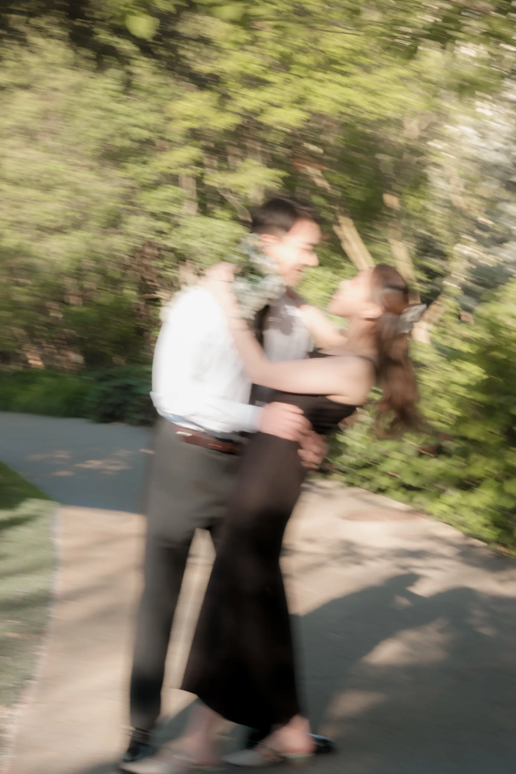 A motion blur frame of Josie and Nelson spinning in an embrace at the Toronto Music Garden, by AD Photography