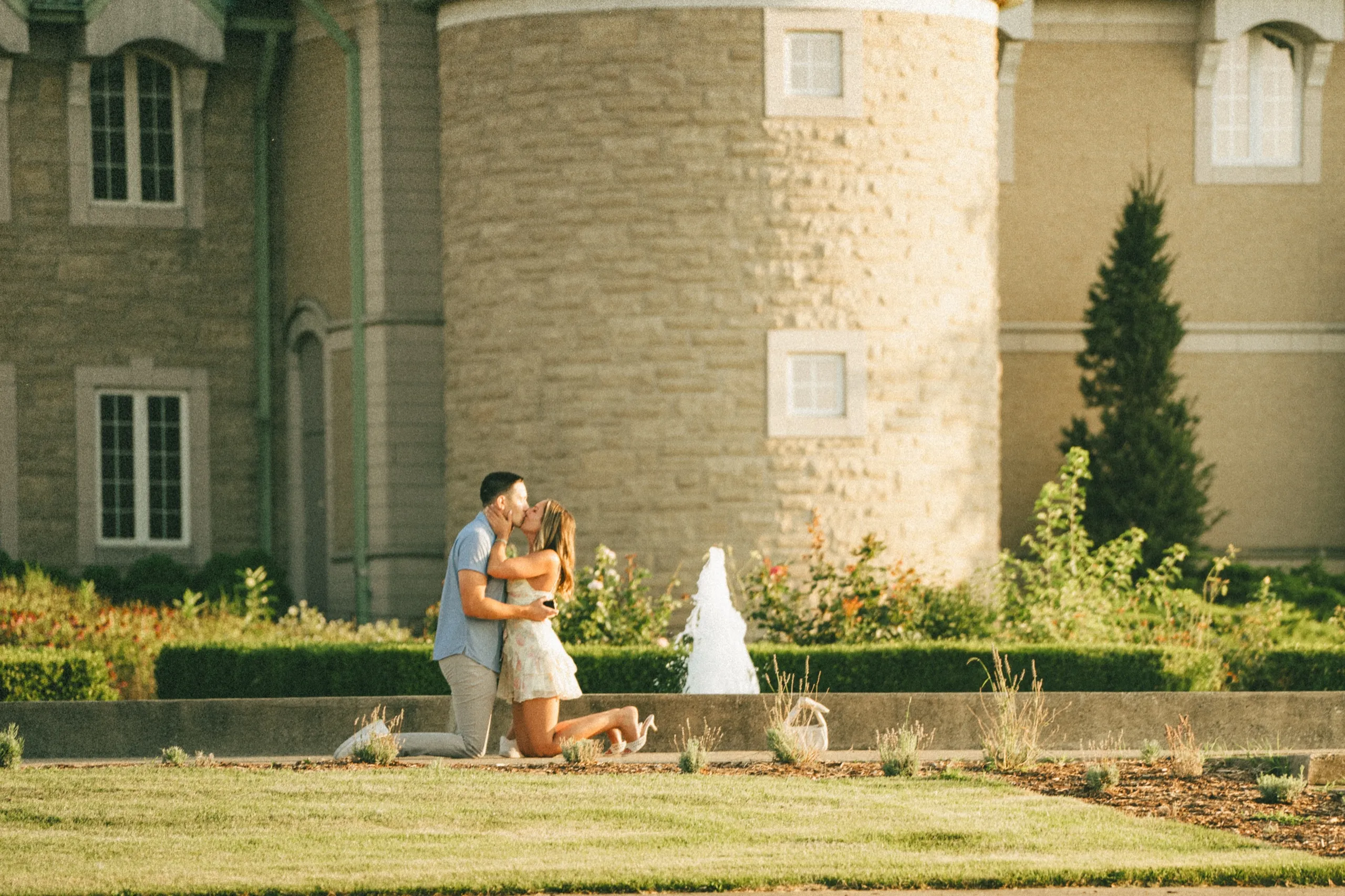 Ashley folding into Donald against the round limestone turret seconds after she said yes, by AD Photography
