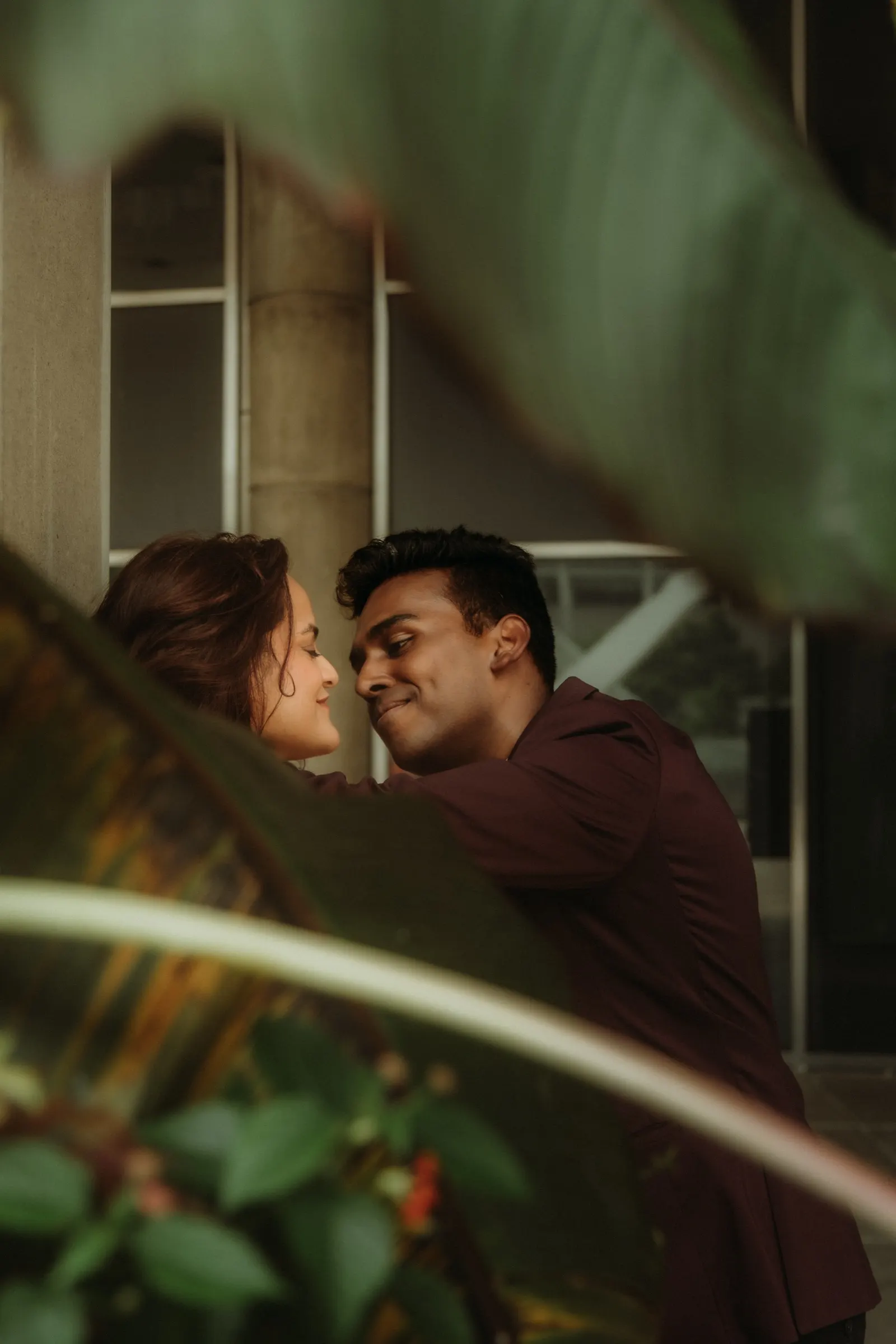 Anushka and Anthony nose to nose under the greenery outside Toronto City Hall after their elopement