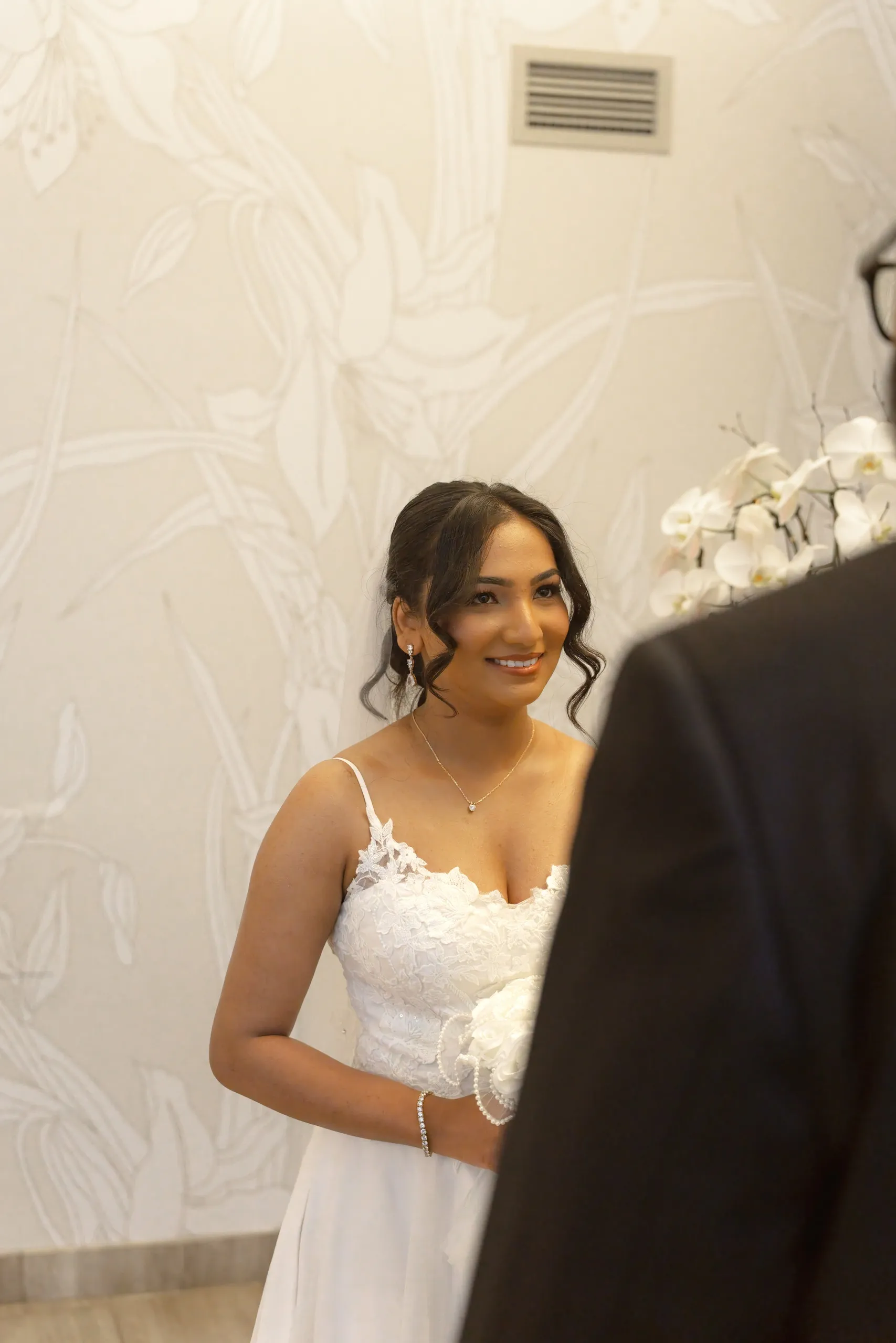 Bride smiles at her groom during the Toronto City Hall wedding chamber ceremony, by AD Photography