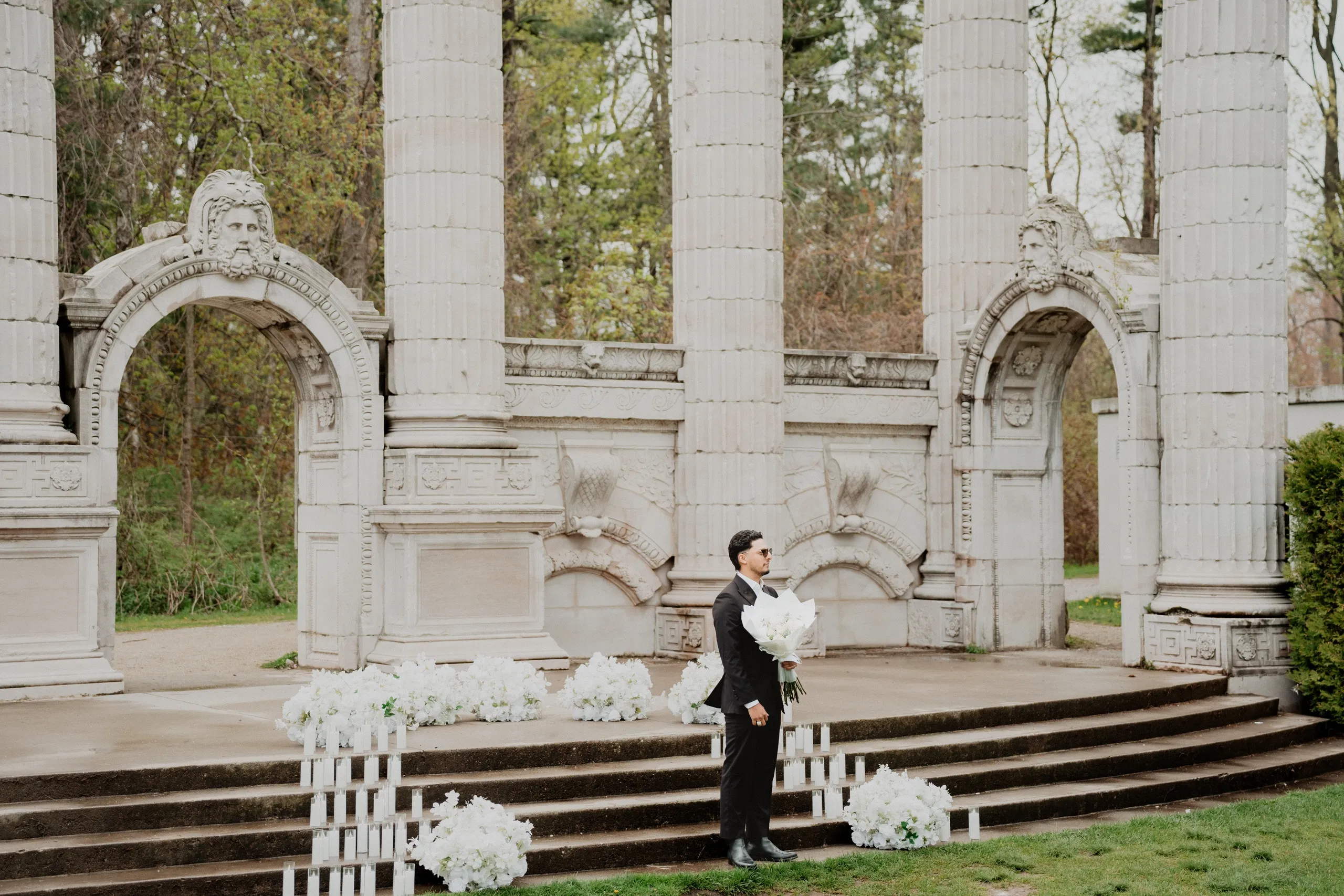 Raeed waiting on the steps at Guild Park and Gardens, bouquet in hand, before Lavina arrives, by AD Photography