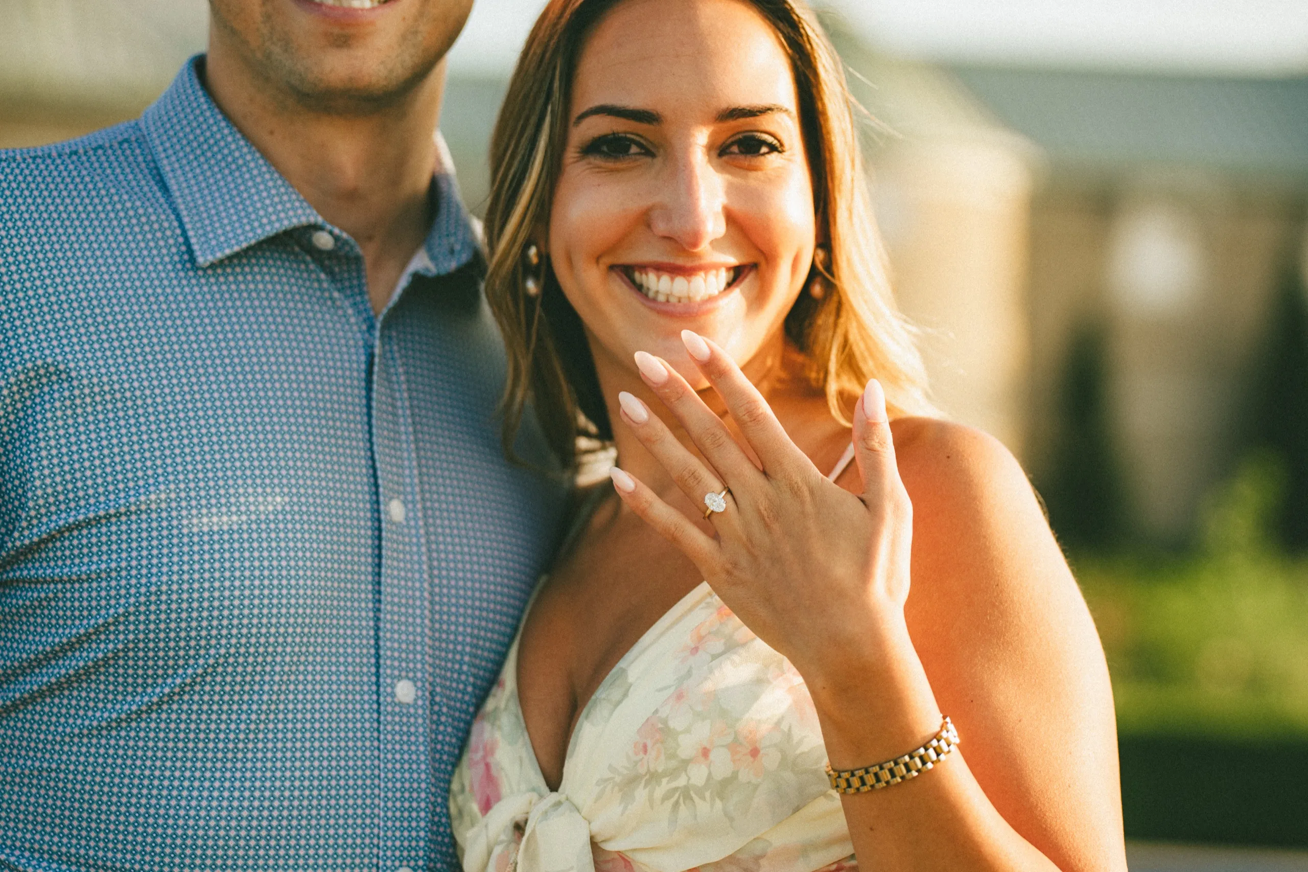 Ashley holding her hand up to show the engagement ring, still laughing, at the winery in St. Davids, by AD Photography