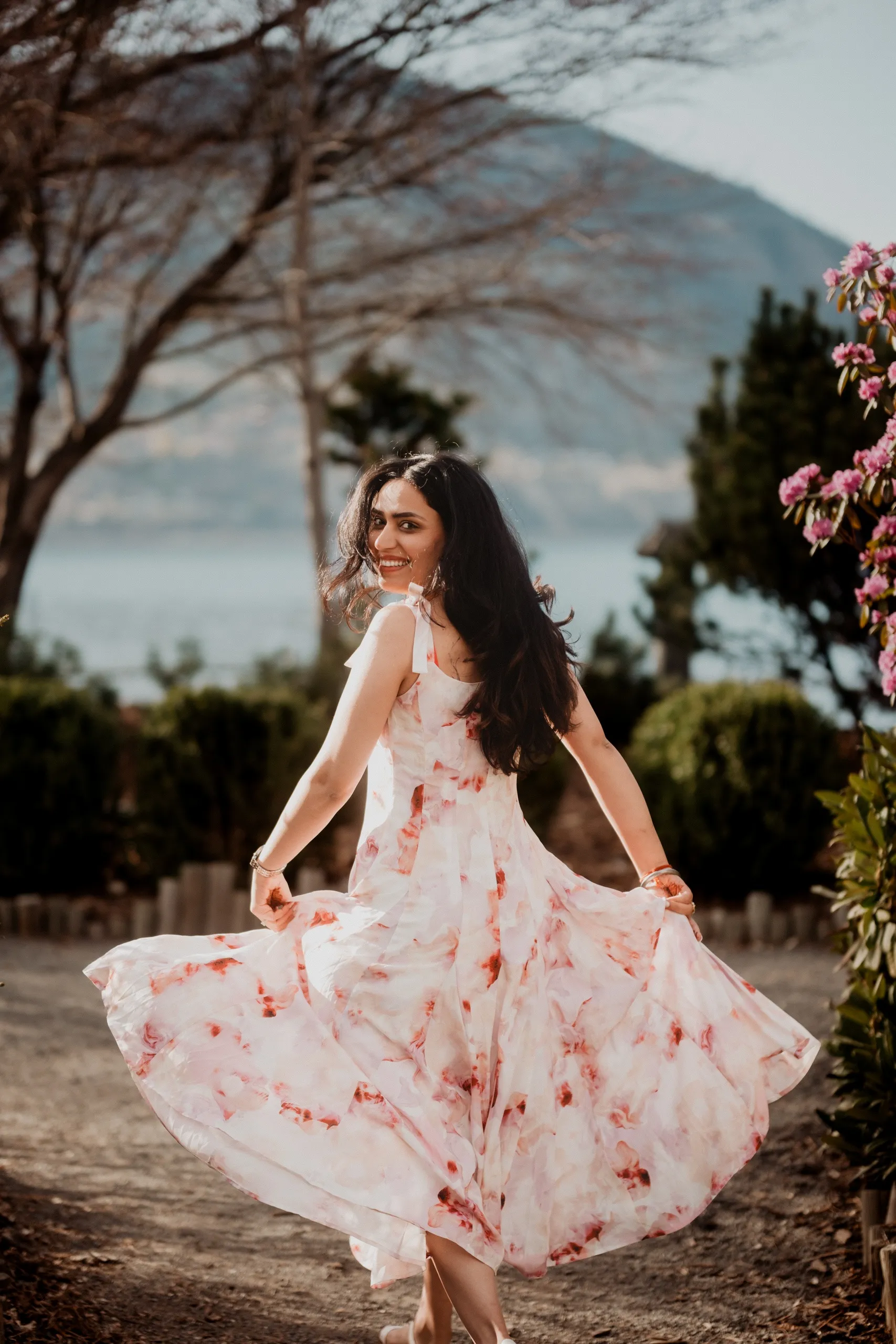 Mehak twirling her floral dress on a gravel path above the lake in Penticton, by AD Photography