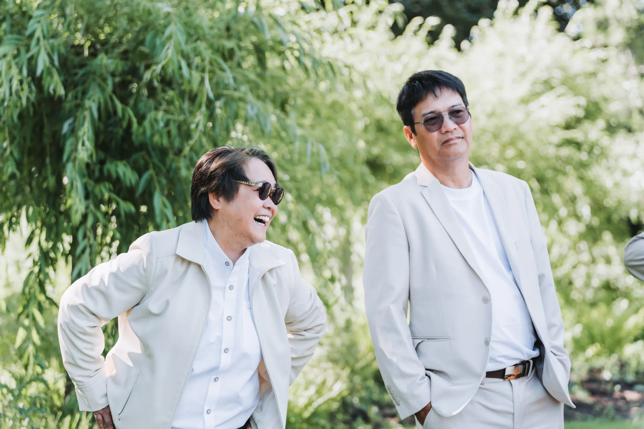 A guest doubled over laughing under the willow at Karen and Micheal's Botanical Gardens wedding in Niagara Falls, by AD Photography