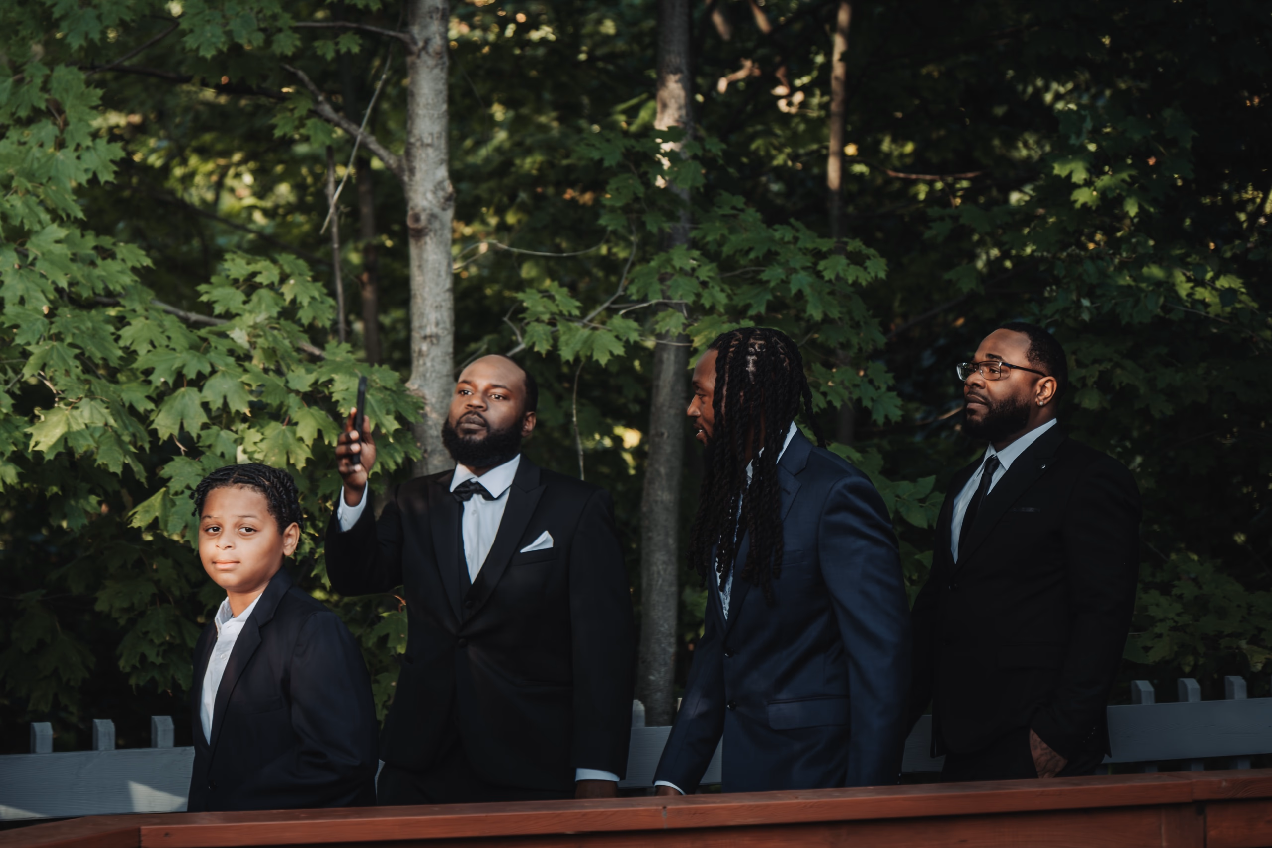 An outdoor wedding ceremony on the deck at The Glenerin Inn, Mississauga, under a canopy of tall maples in September light, by AD Photography