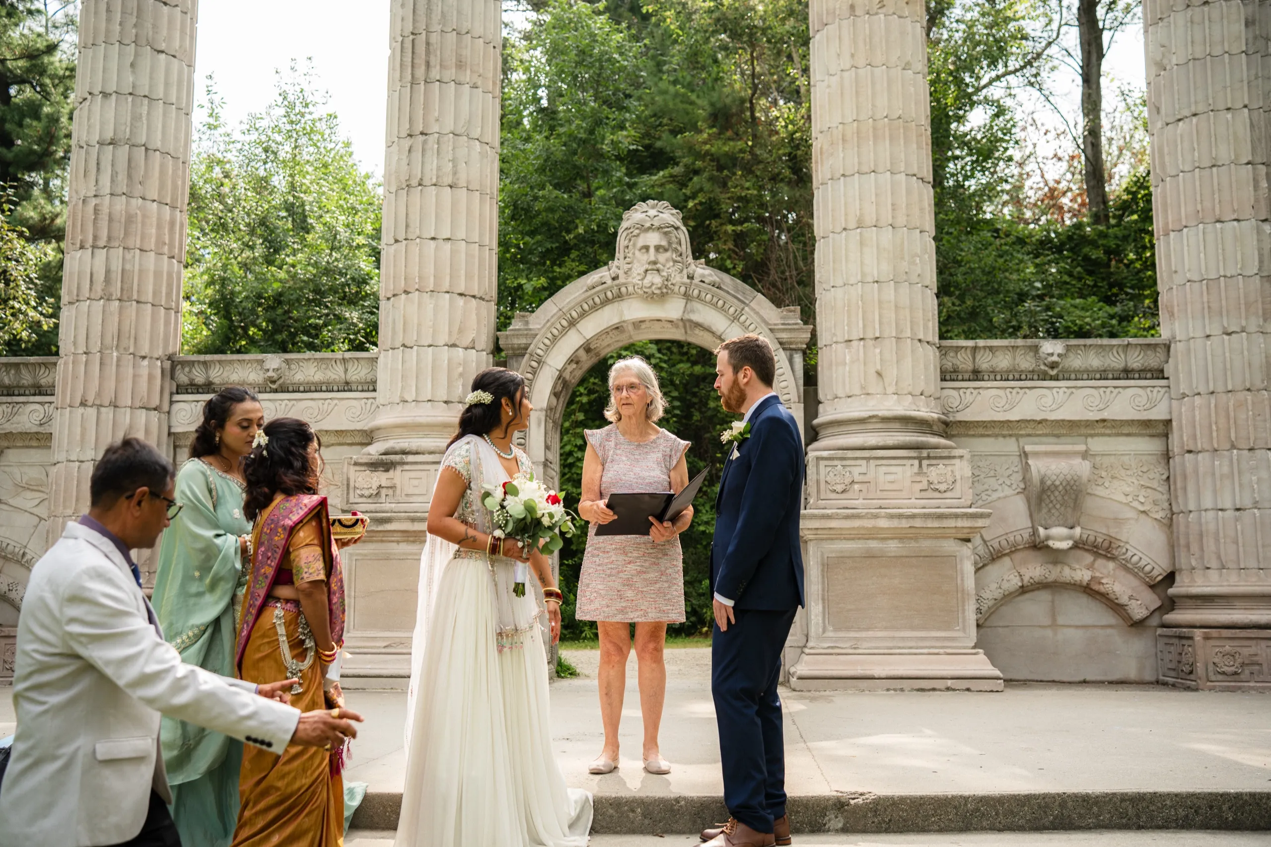 Family gathers close as Nidhi and Derek begin their civil ceremony beneath the columns., by AD Photography