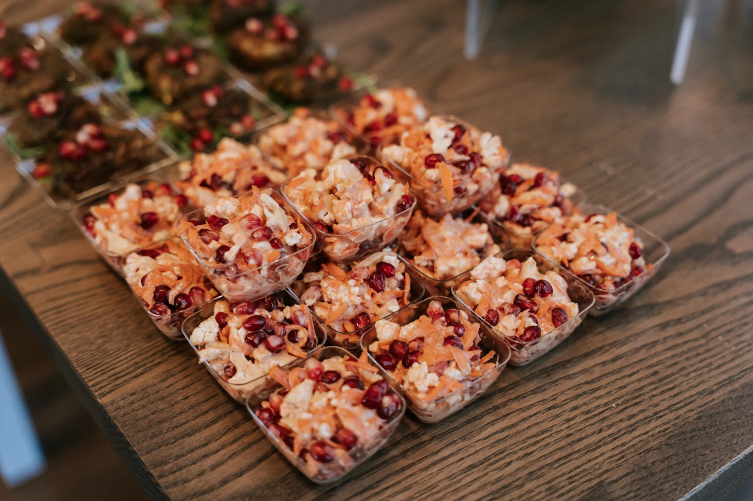 Cauliflower, carrot and pomegranate cups beside stuffed grape leaves on the celebration table, by AD Photography