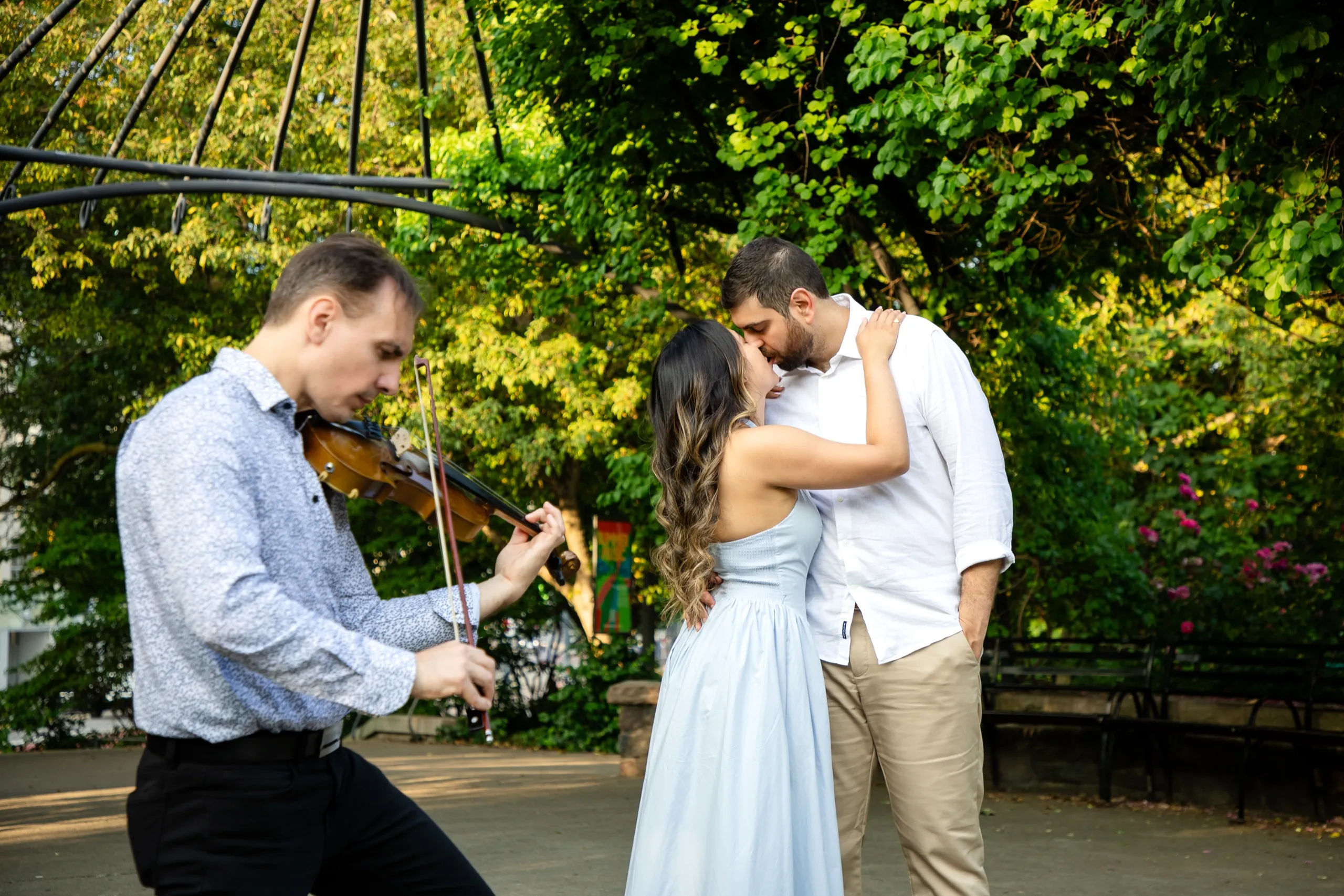 Margarita and Mike kissing while a live violinist plays at the Toronto Music Garden, by AD Photography