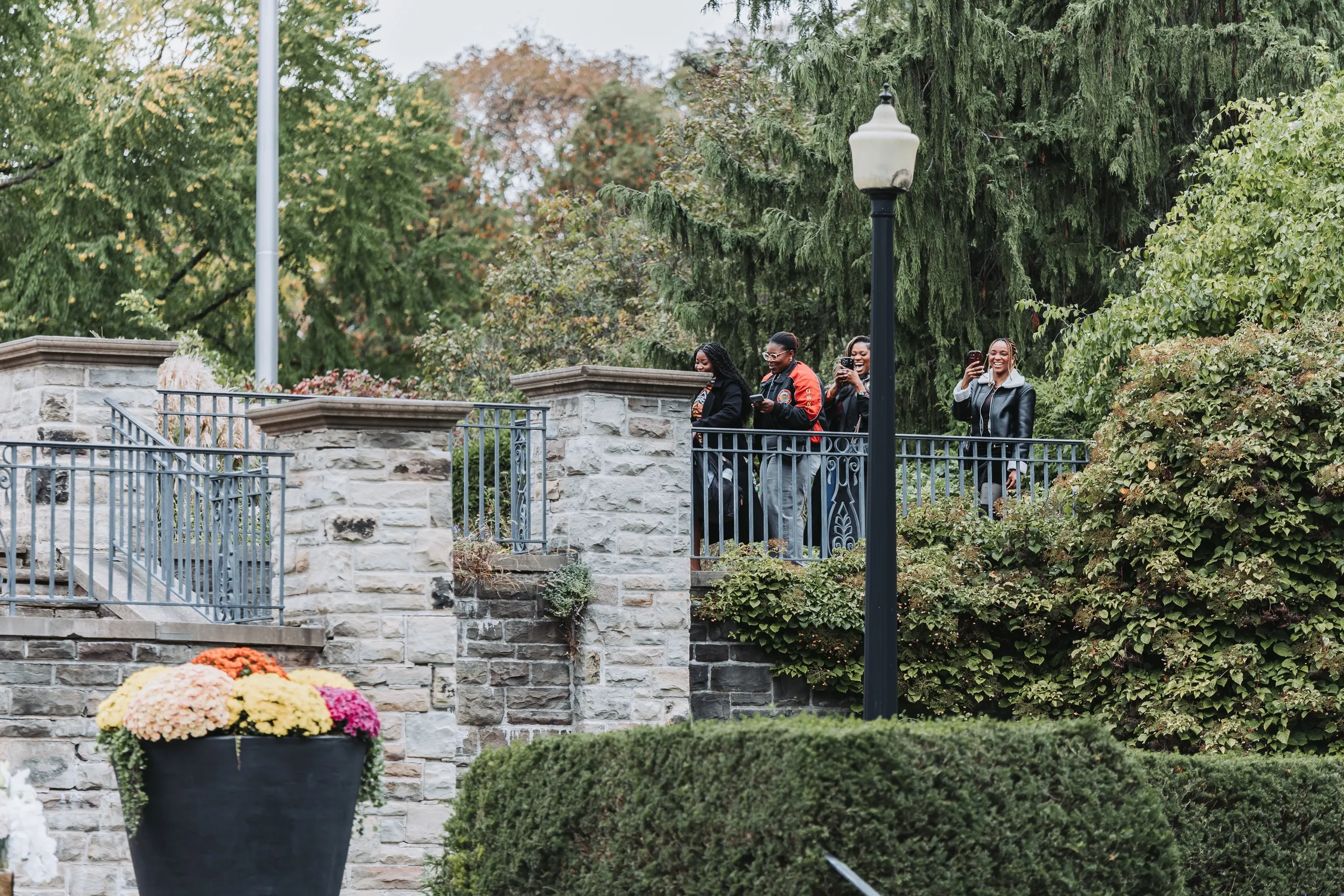 Family watching from the upper terrace behind the iron railing after the proposal, by AD Photography