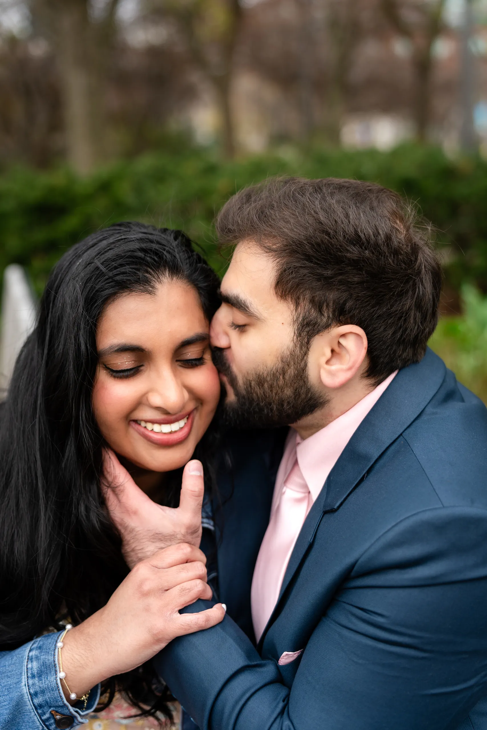 Abdullah kisses Nadia on the cheek as she laughs on a garden bench in Toronto, by AD Photography