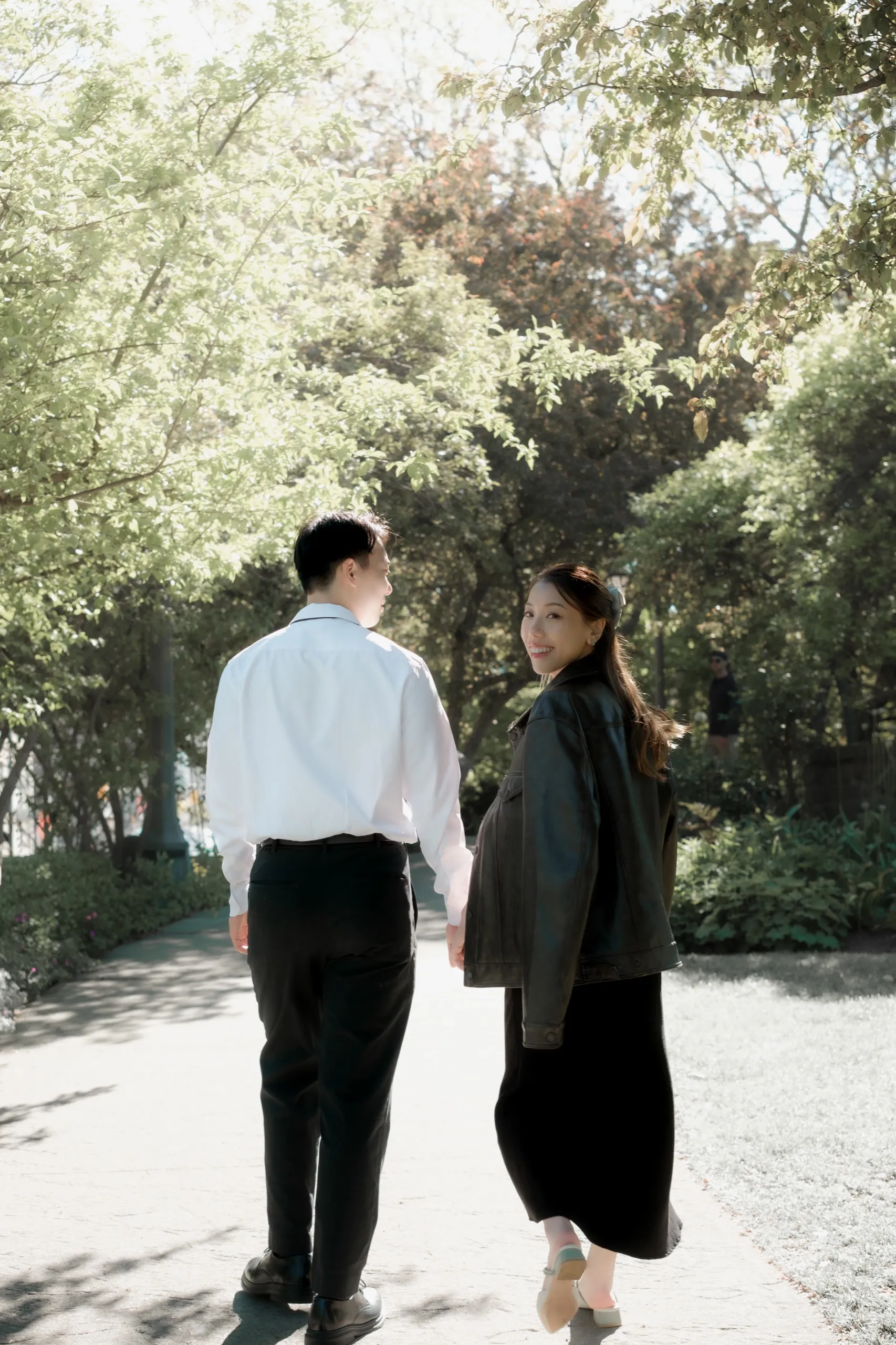 Josie and Nelson stand together in dappled tree light at the Toronto Music Garden, by AD Photography