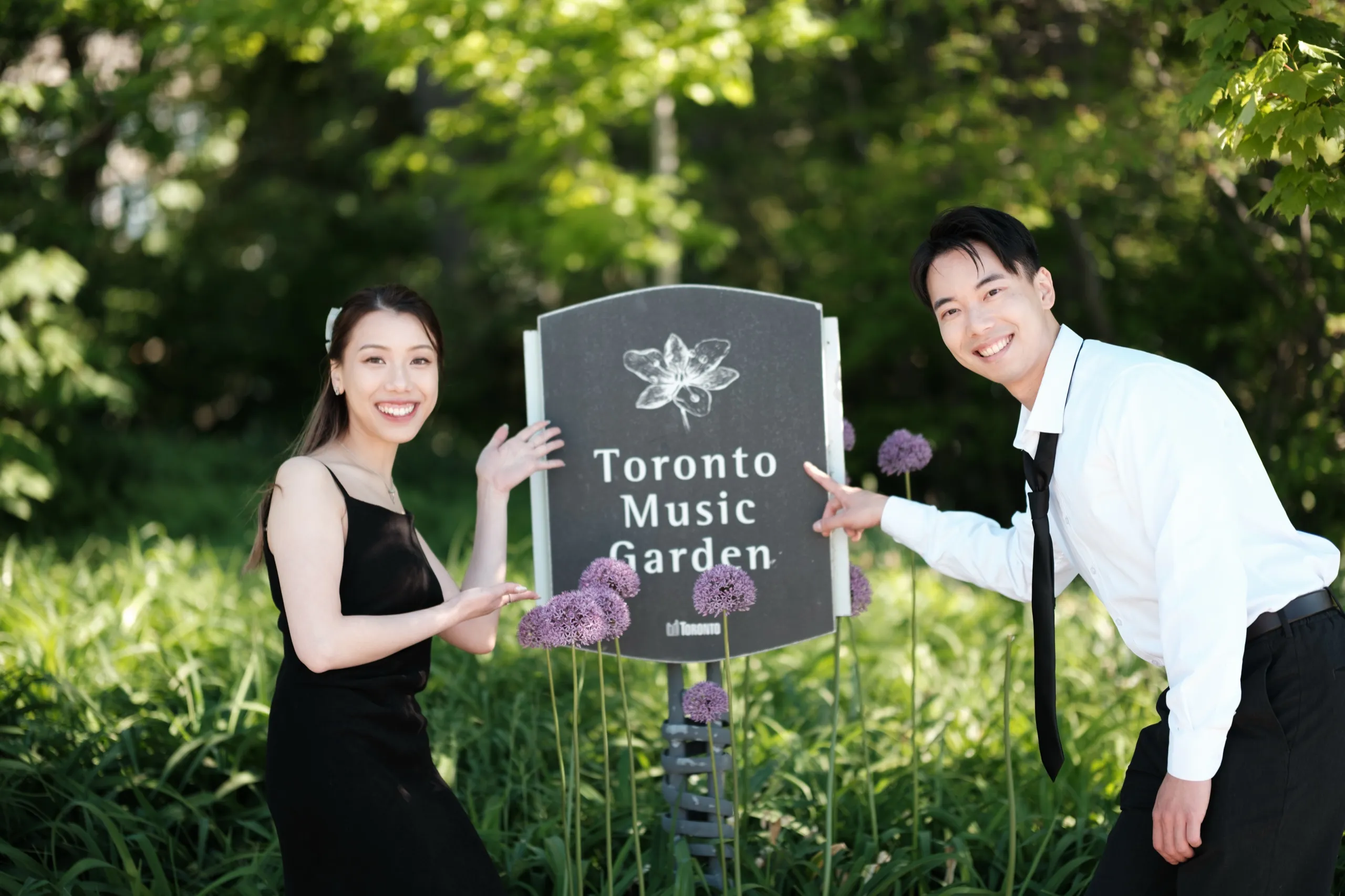 Josie and Nelson share a laugh beside the Toronto Music Garden sign on the Harbourfront, by AD Photography