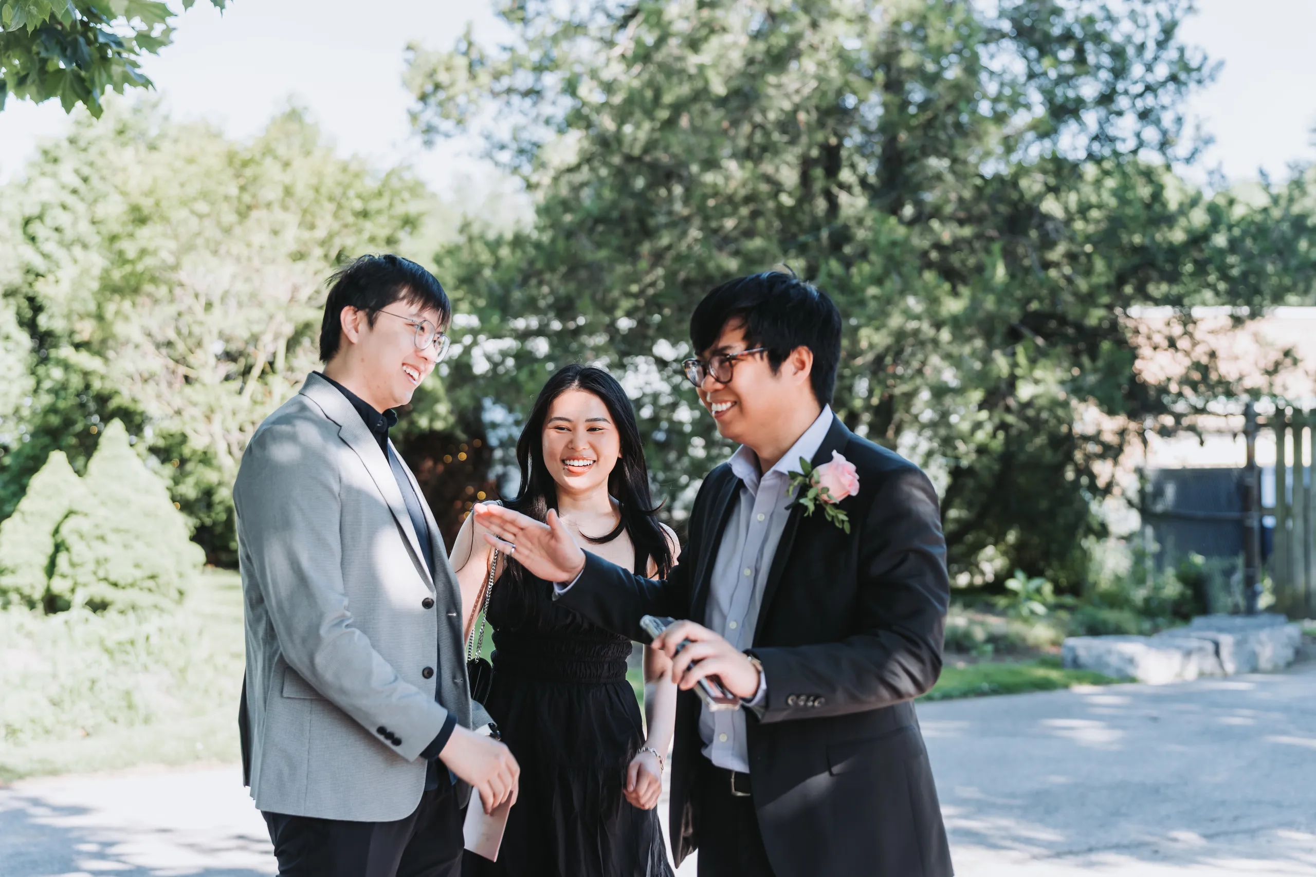 Three guests laughing together on the garden path at Karen and Micheal's Niagara Falls wedding, by AD Photography