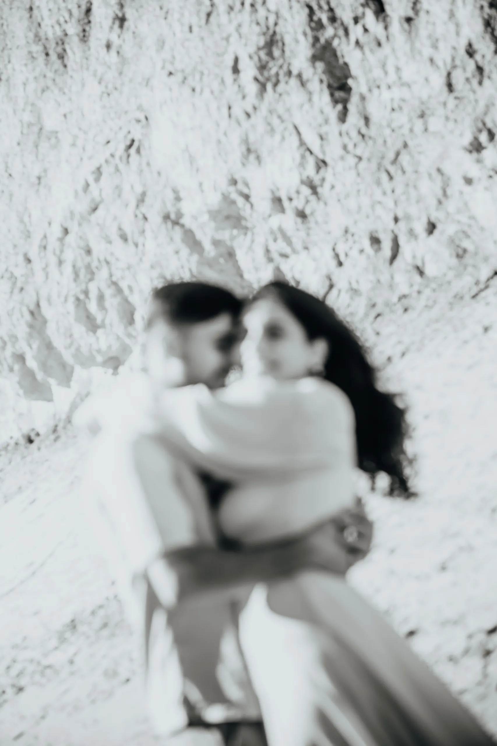 Grainy black and white soft focus frame of Swati and Saksham laughing in an embrace, by AD Photography