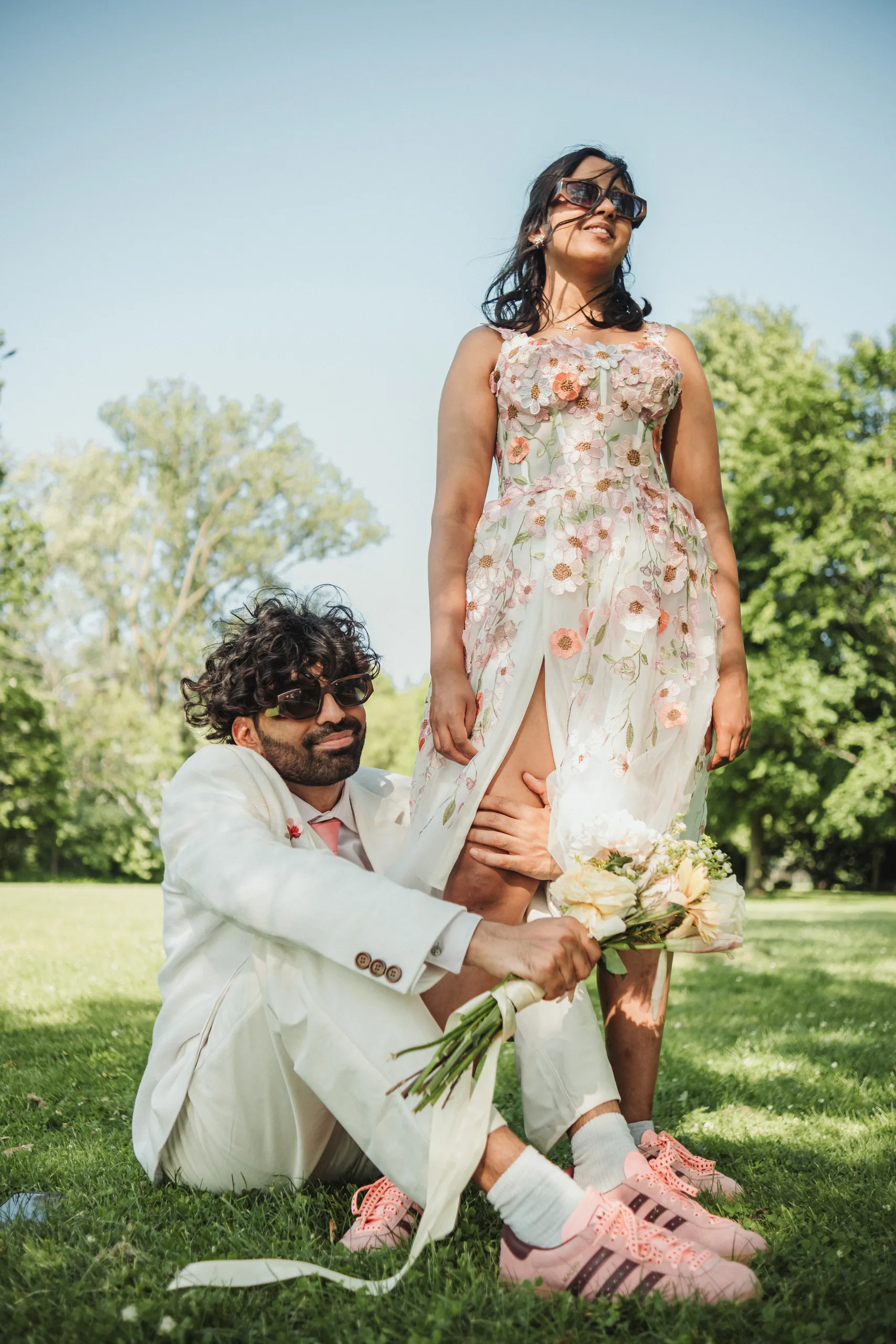 An editorial portrait of Payal standing over a seated Harsh on the lawn, Toronto Islands, by AD Photography