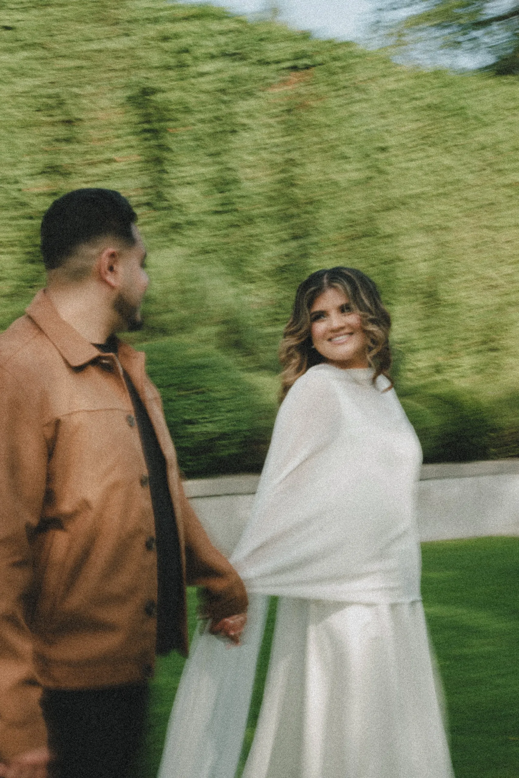 Panning blur of Maninder towing Parneet by the hand as she beams back at him, by AD Photography