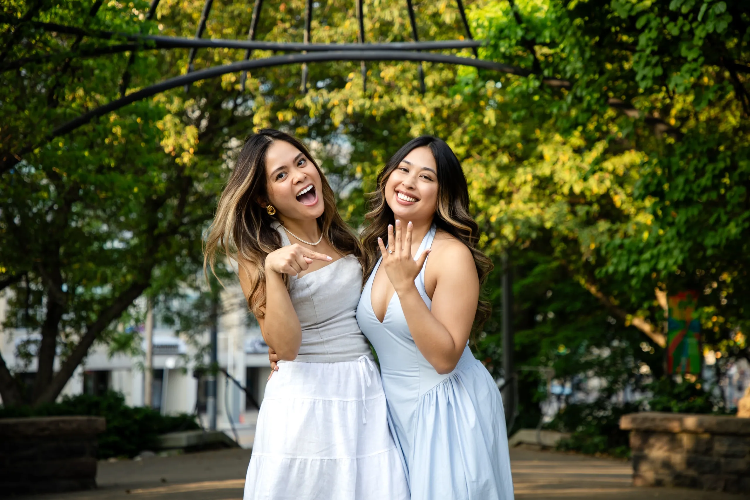 Margarita showing her engagement ring to her best friend at the Toronto Music Garden, by AD Photography