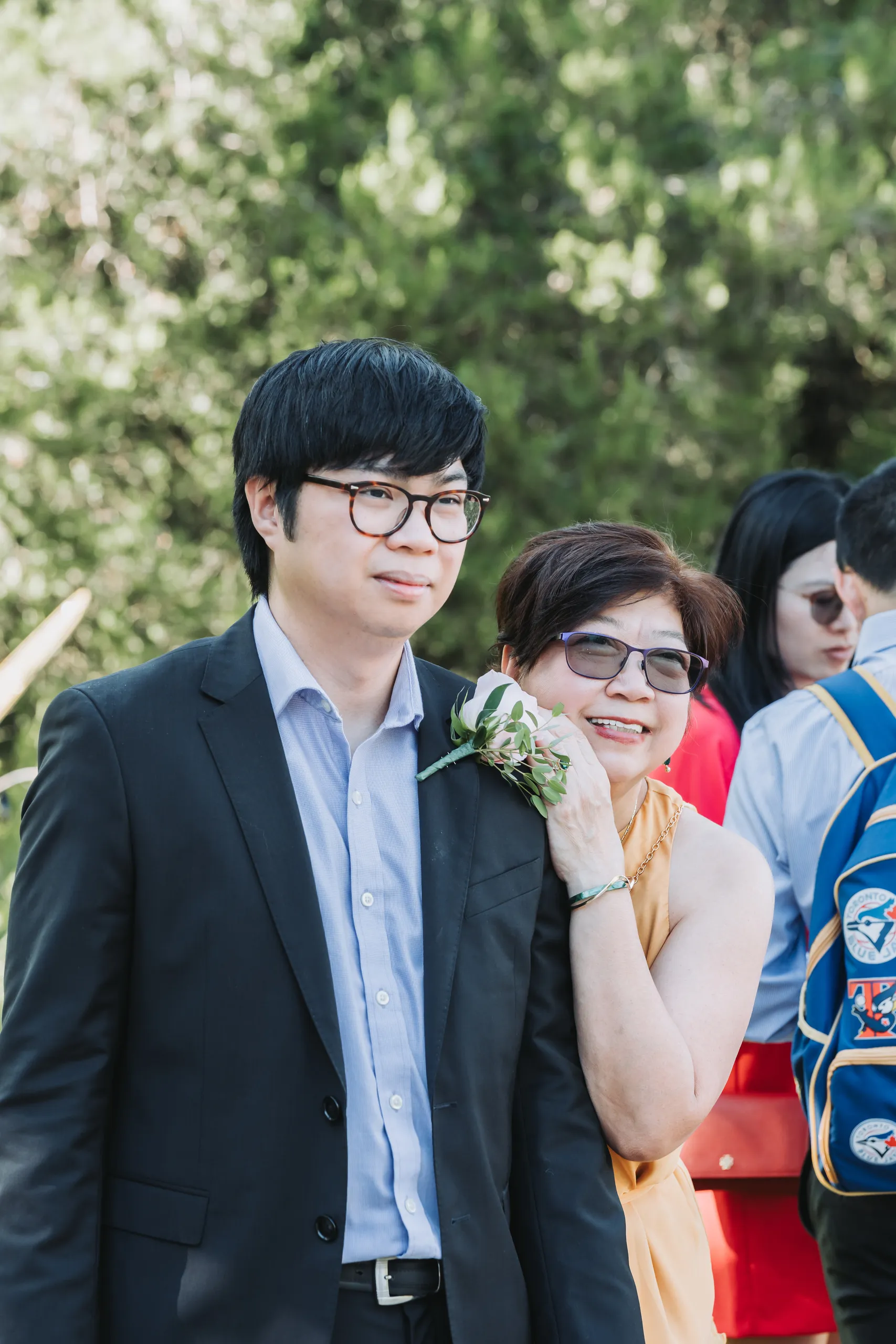Micheal's mother leaning on his shoulder laughing before the ceremony at the Botanical Gardens, by AD Photography