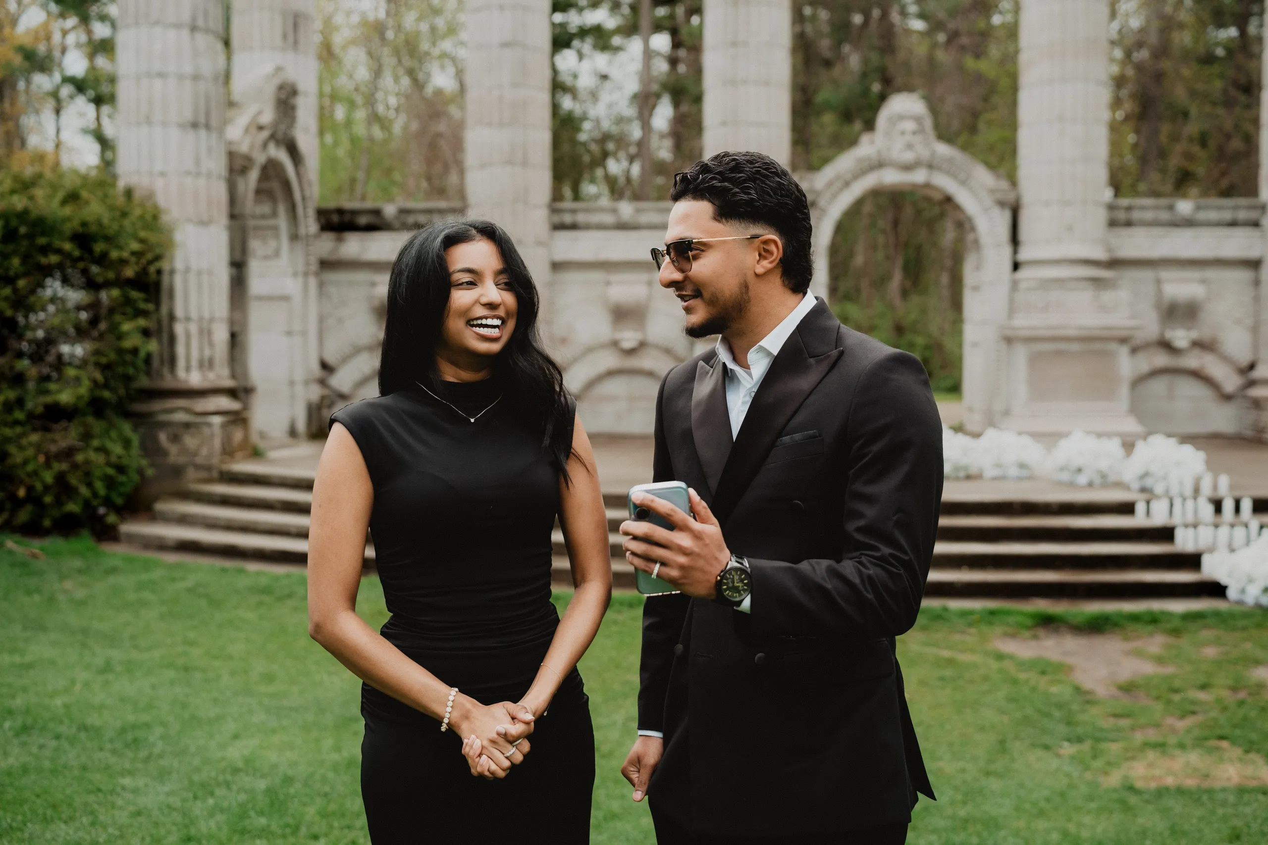 Lavina and Raeed laughing on the lawn at Guild Park and Gardens, candles still burning behind them, by AD Photography