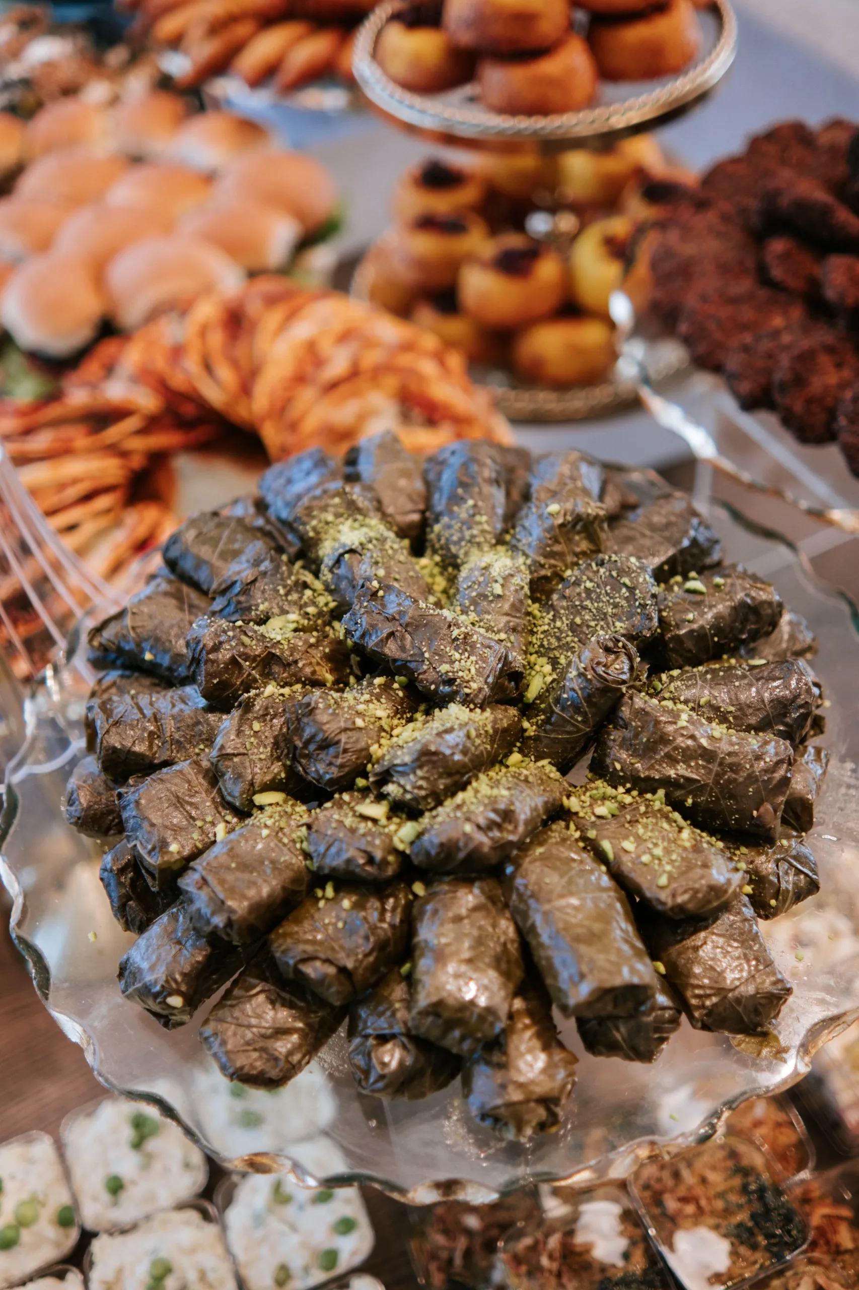 Stuffed grape leaves dusted with pistachio anchor a spread of pastries and savouries, by AD Photography