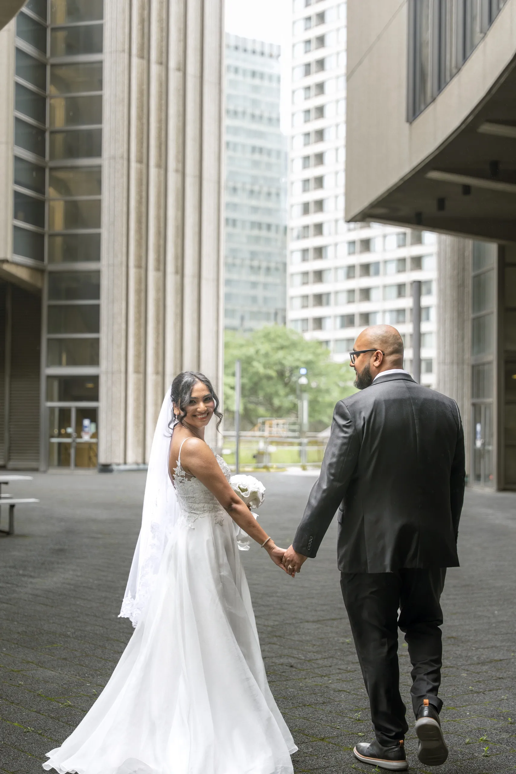 Bride looks back over her shoulder in the New City Hall courtyard, by AD Photography