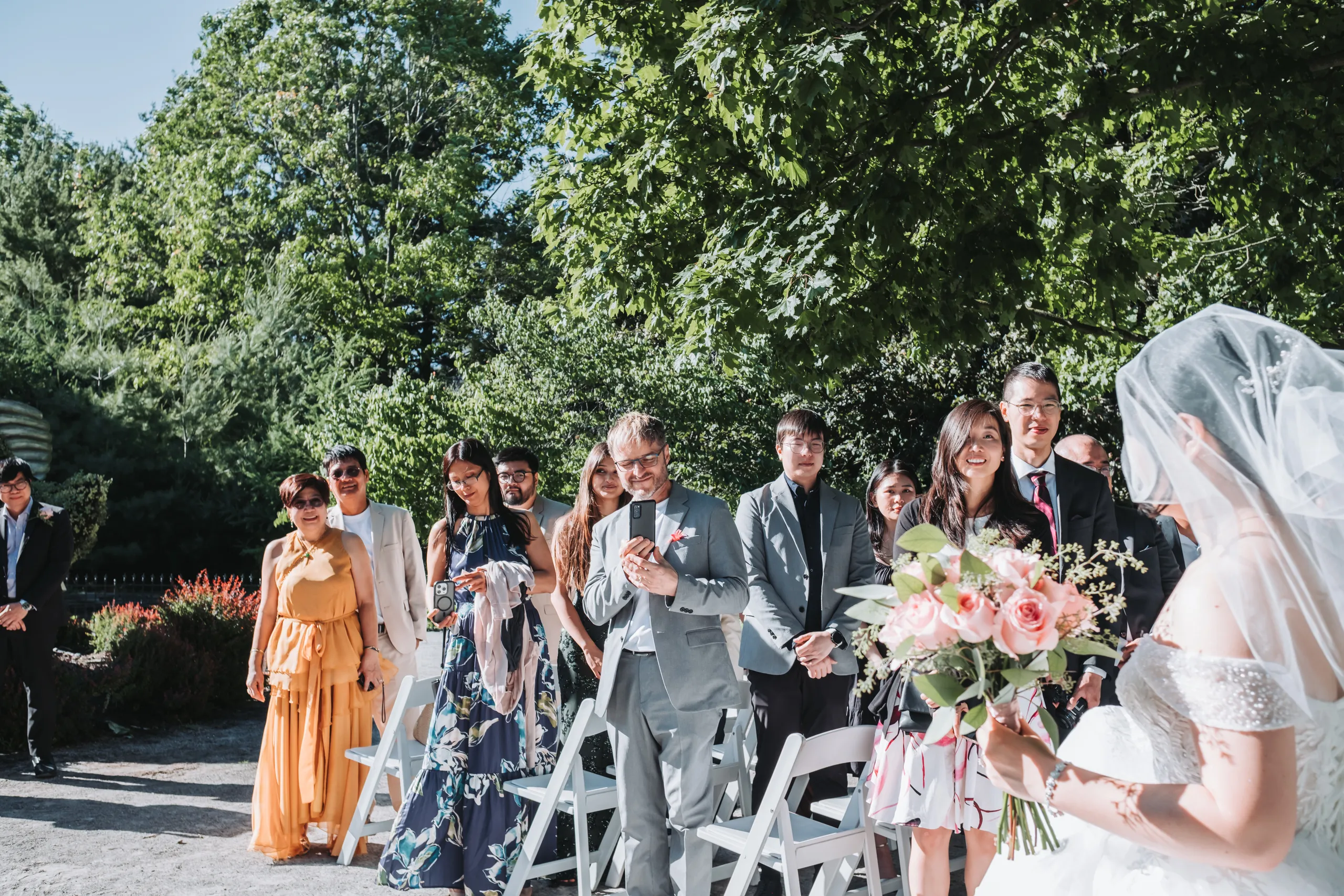 A bridesmaid walking the garden aisle with her bouquet before the ceremony in Niagara Falls, by AD Photography
