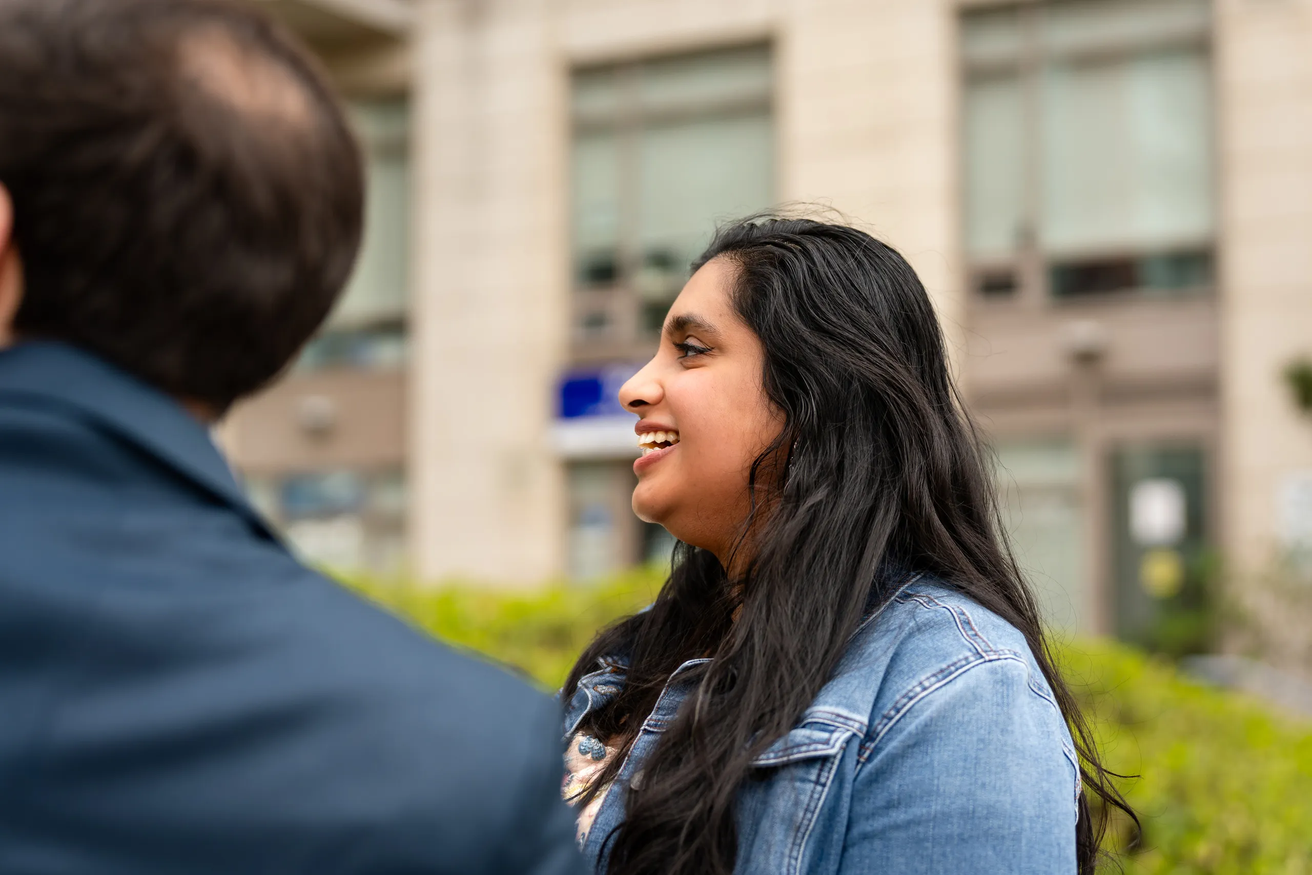 Nadia laughs in a soft focus profile portrait on a Toronto street, by AD Photography