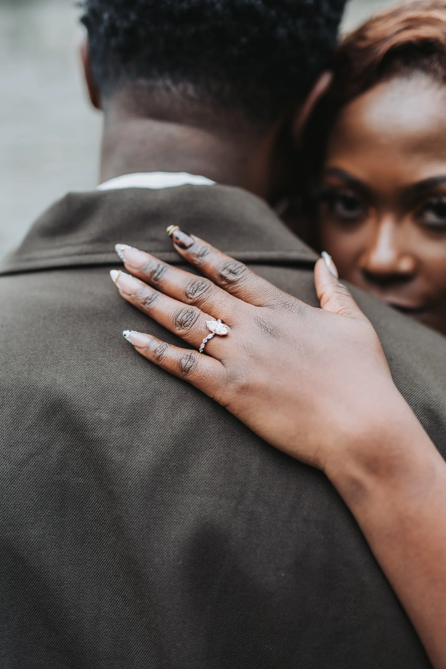 Aimee's ring hand on Richie's shoulder as she peeks at the camera from behind him, by AD Photography