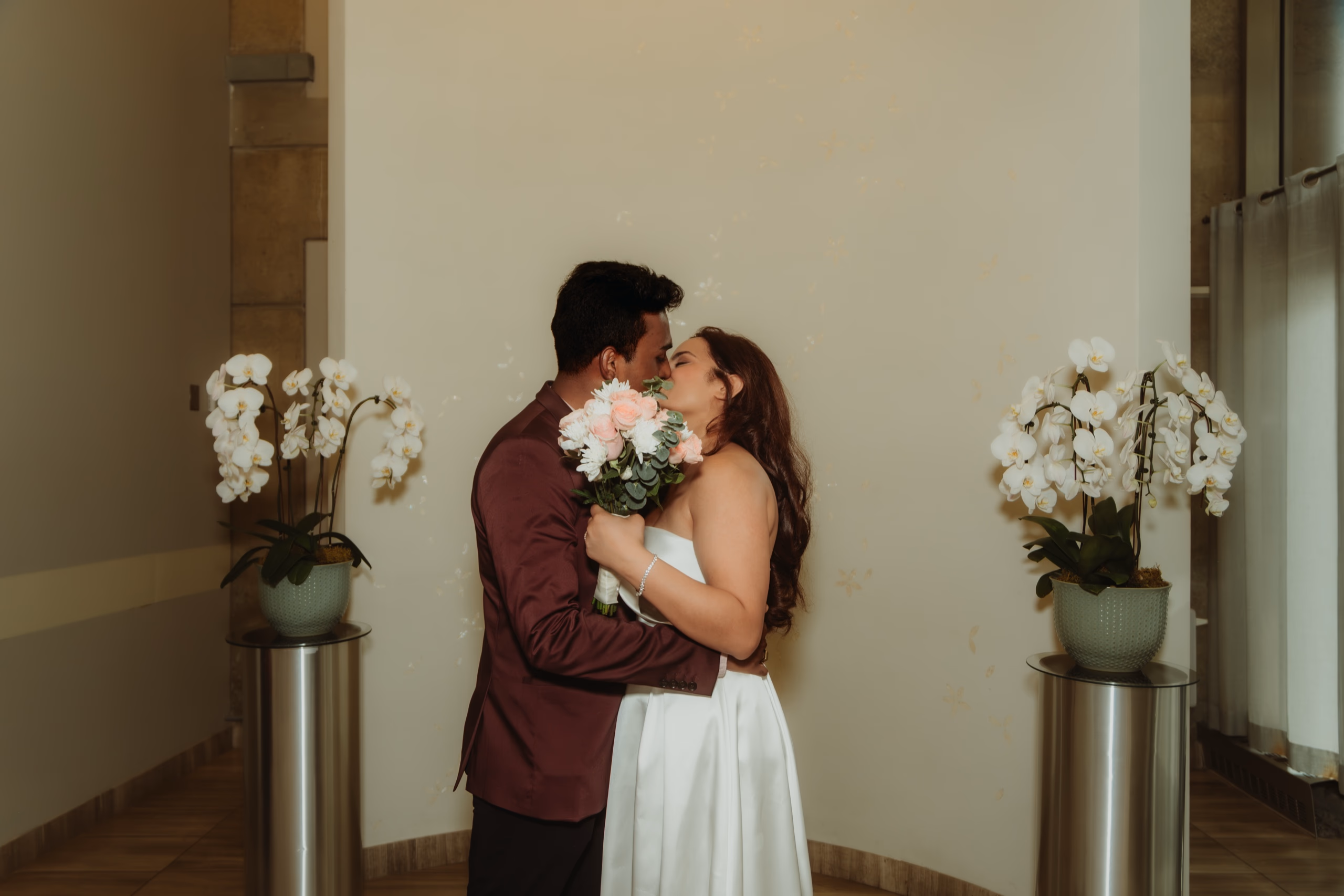 Their first kiss as a married couple, bouquet pressed between them in the chamber