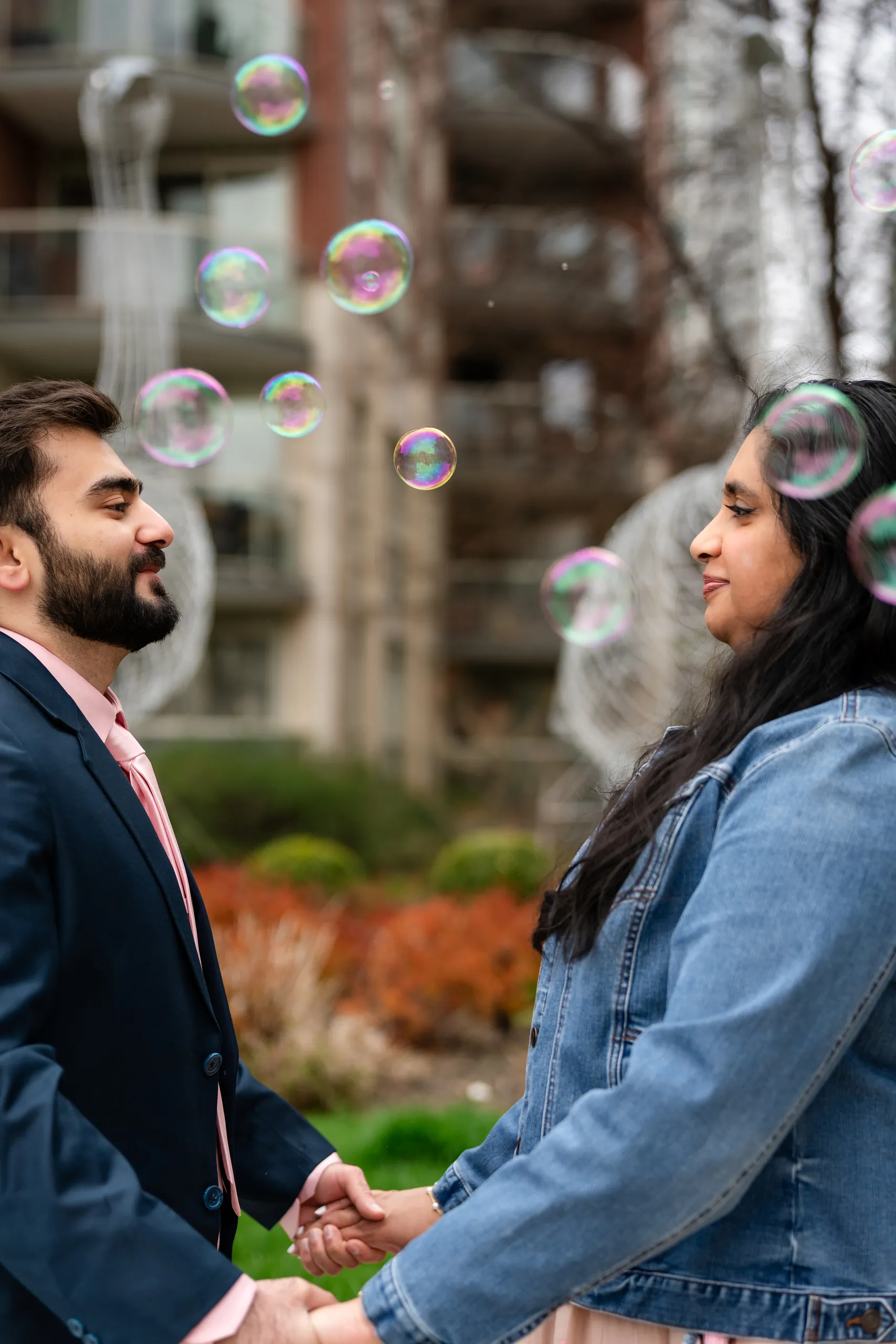 Abdullah and Nadia face each other through a drift of bubbles in a Harbourfront courtyard, by AD Photography