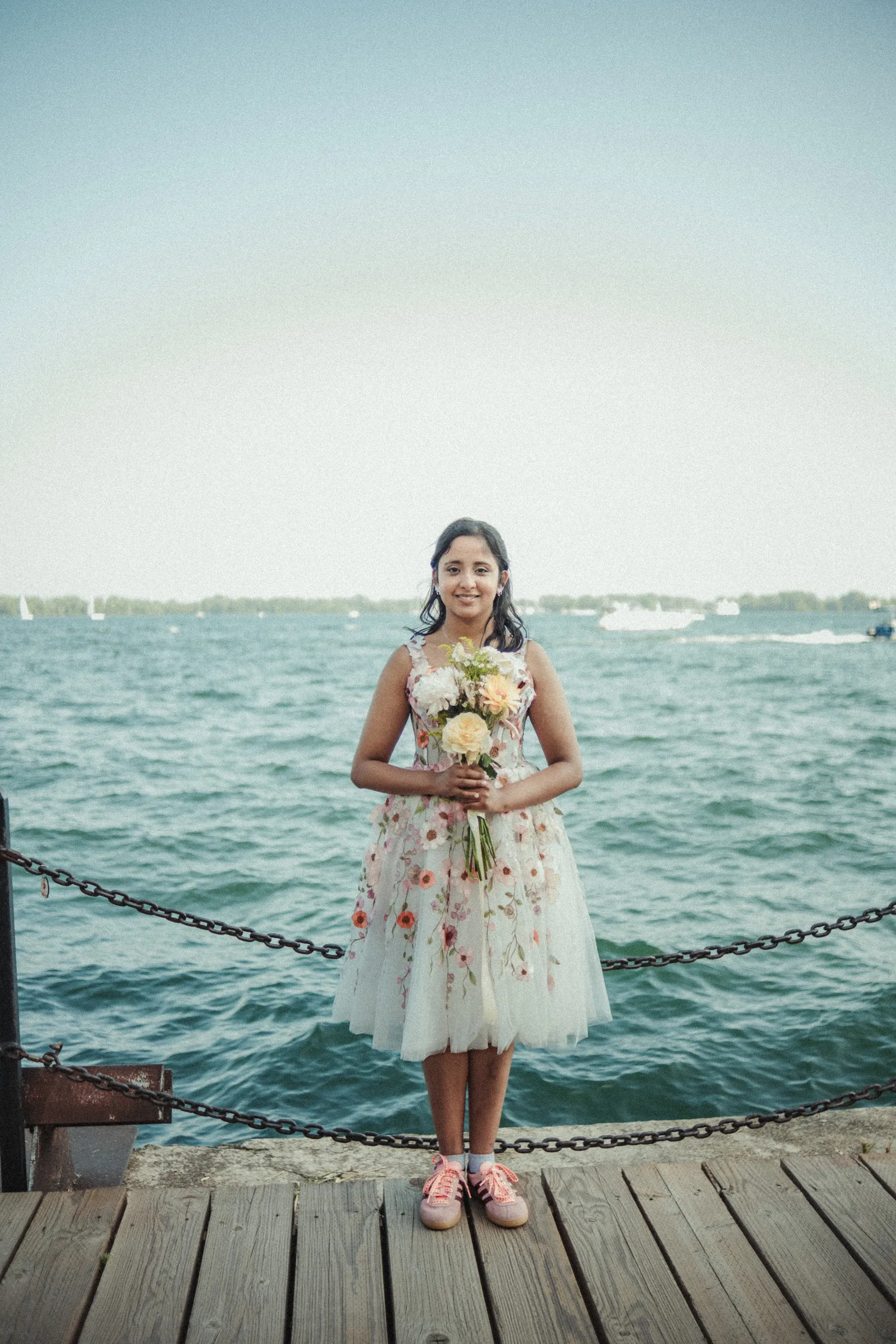 Payal alone by the water with sailboats behind her on the Toronto Islands, by AD Photography
