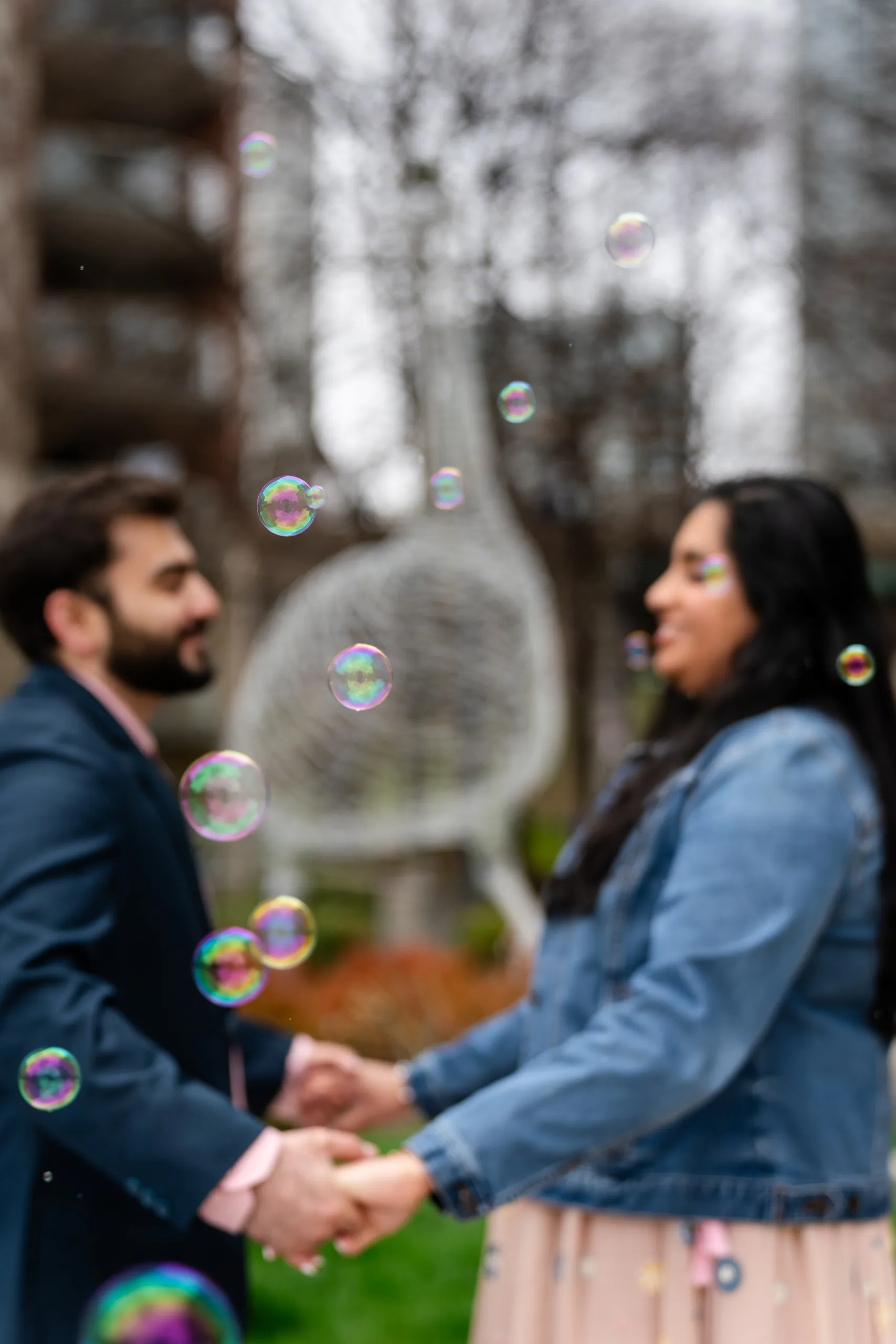 Soft focus portrait of Abdullah and Nadia holding hands among floating bubbles in Toronto, by AD Photography
