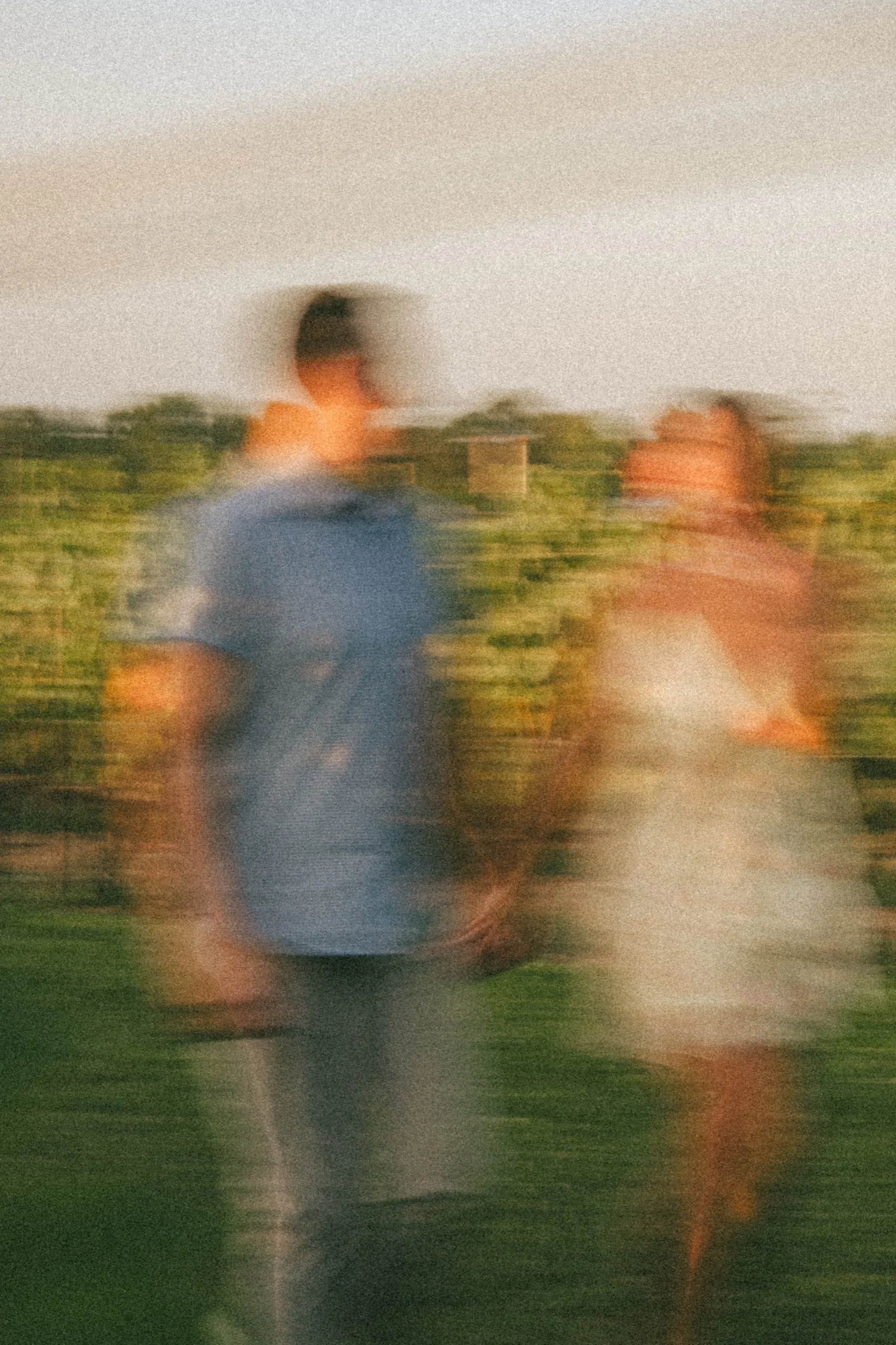 A long exposure of the couple walking the vineyard, both figures dissolved into colour, by AD Photography