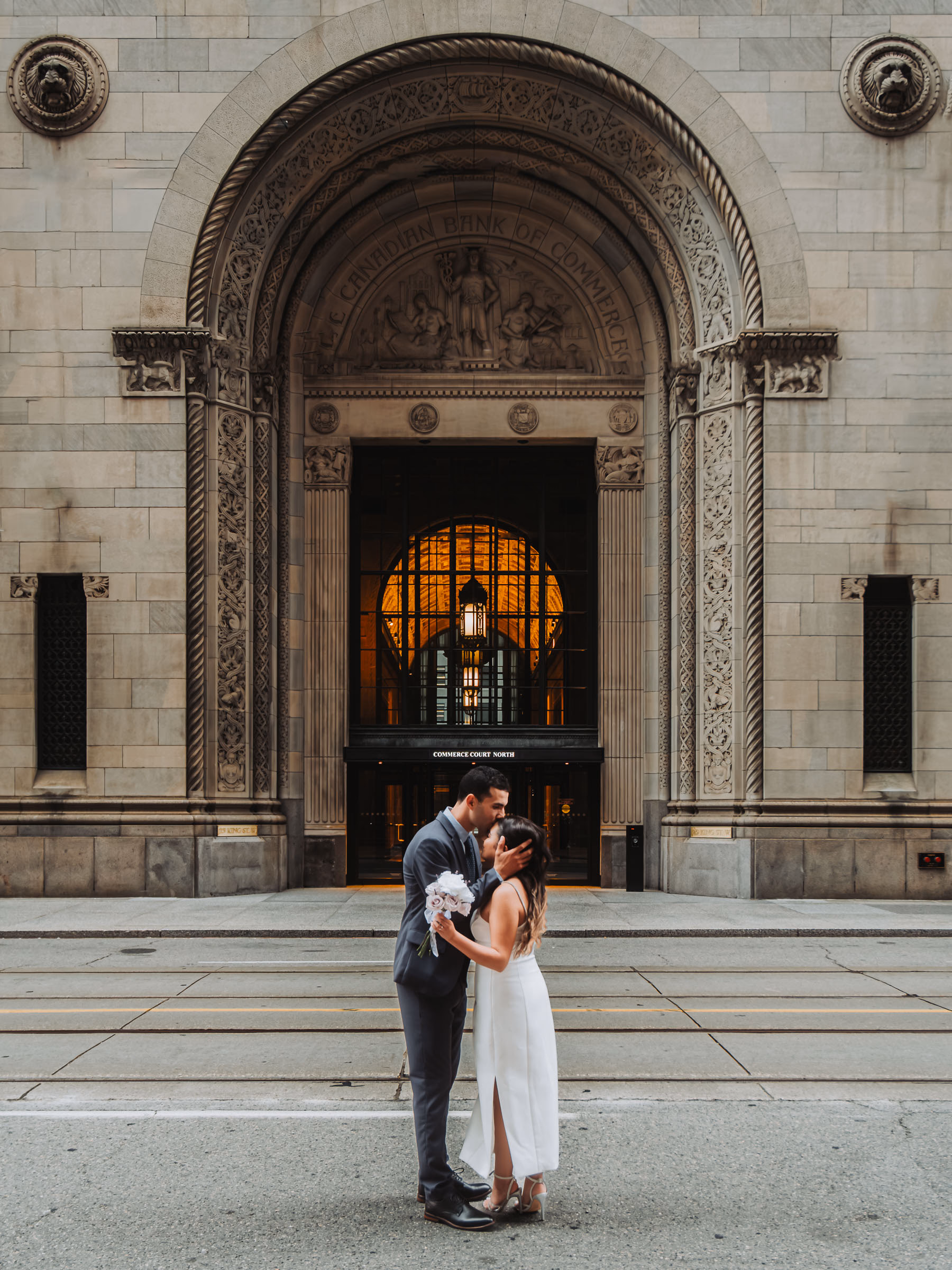 A kiss at the foot of the grand stone entrance, Alex's bouquet pressed to Aziz's chest