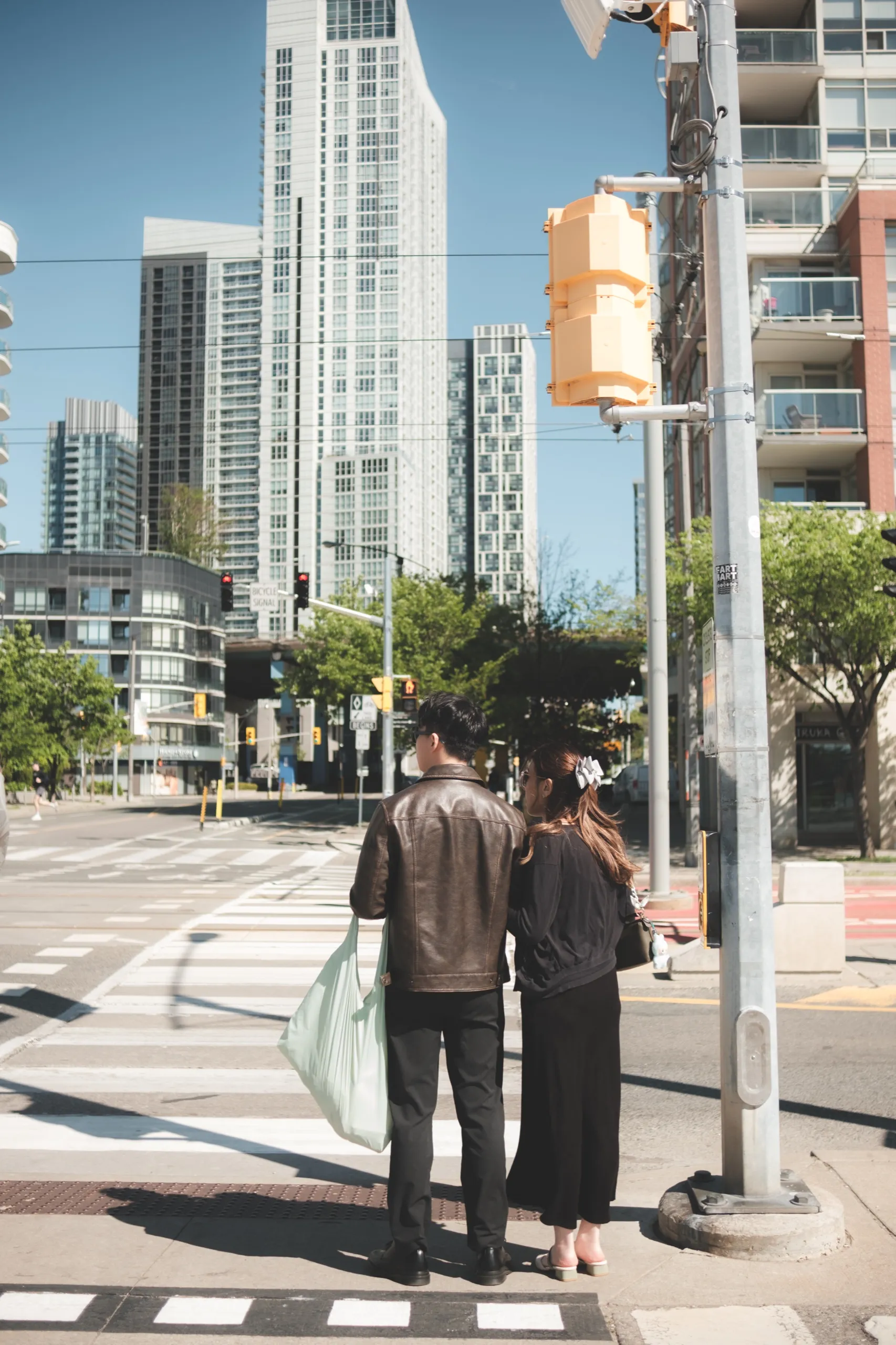 Josie and Nelson cross a downtown street hand in hand, seen from behind in an editorial frame, by AD Photography