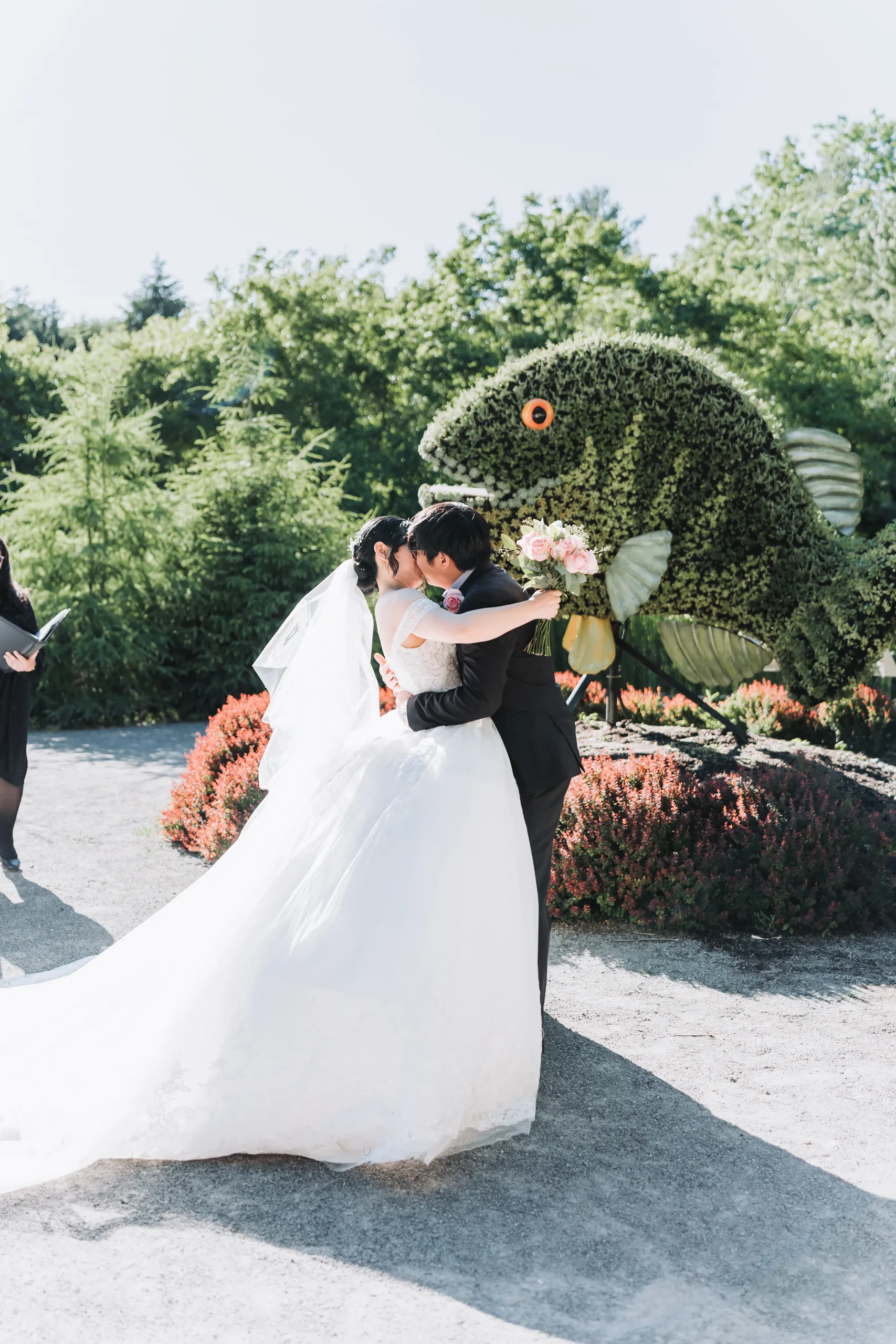 Karen and Micheal's first kiss in front of the living fish sculpture at the Botanical Gardens, by AD Photography