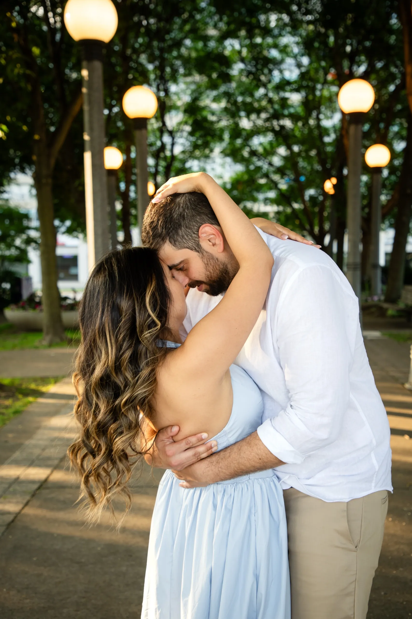 A dip kiss under the glowing lamp posts on the Harbourfront promenade beside the Toronto Music Garden, by AD Photography