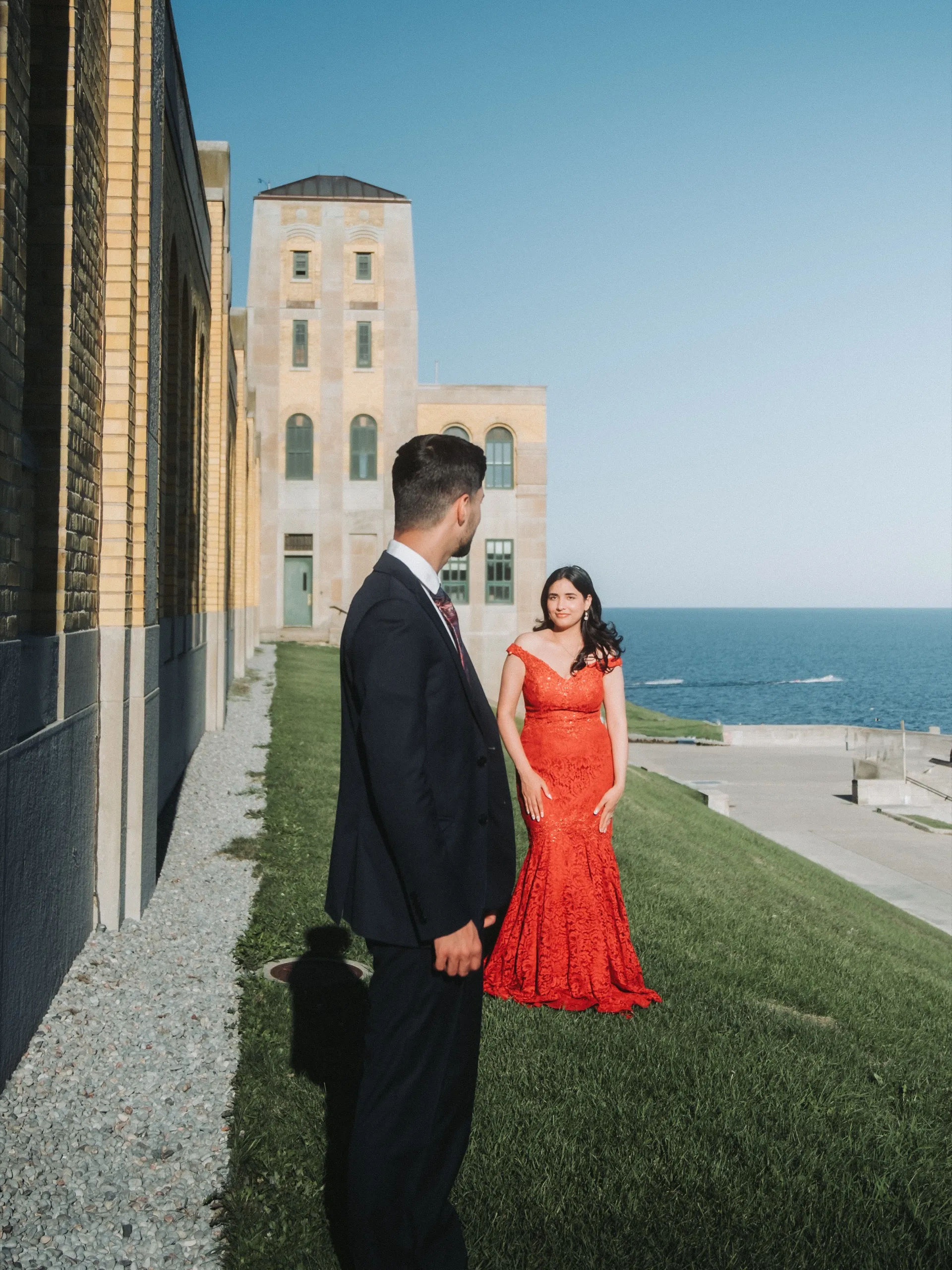 Saksham turns to find Swati in her red gown beside the yellow brick waterworks, by AD Photography