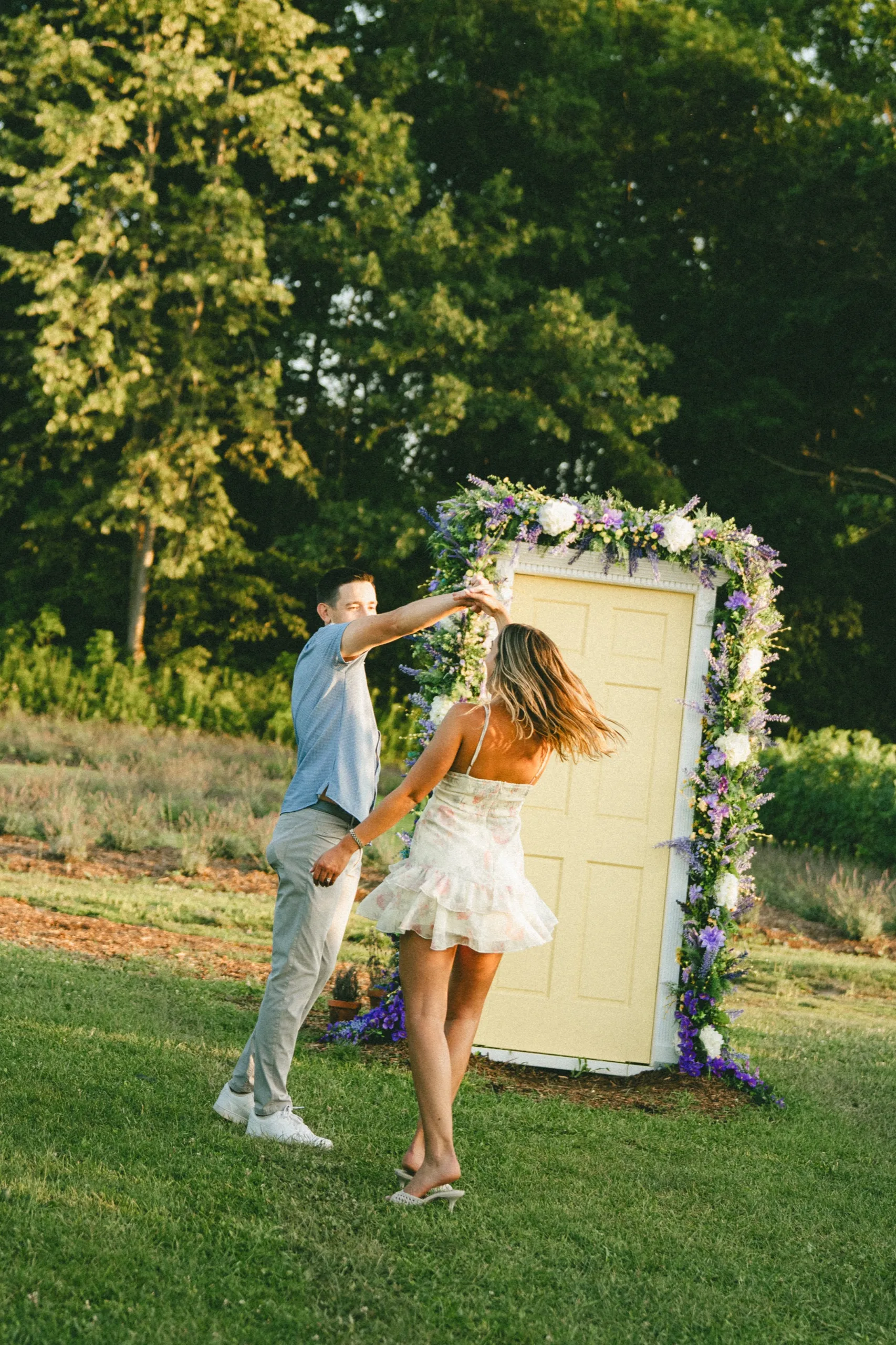 Donald spinning Ashley in front of the floral door, her skirt and hair still moving, by AD Photography