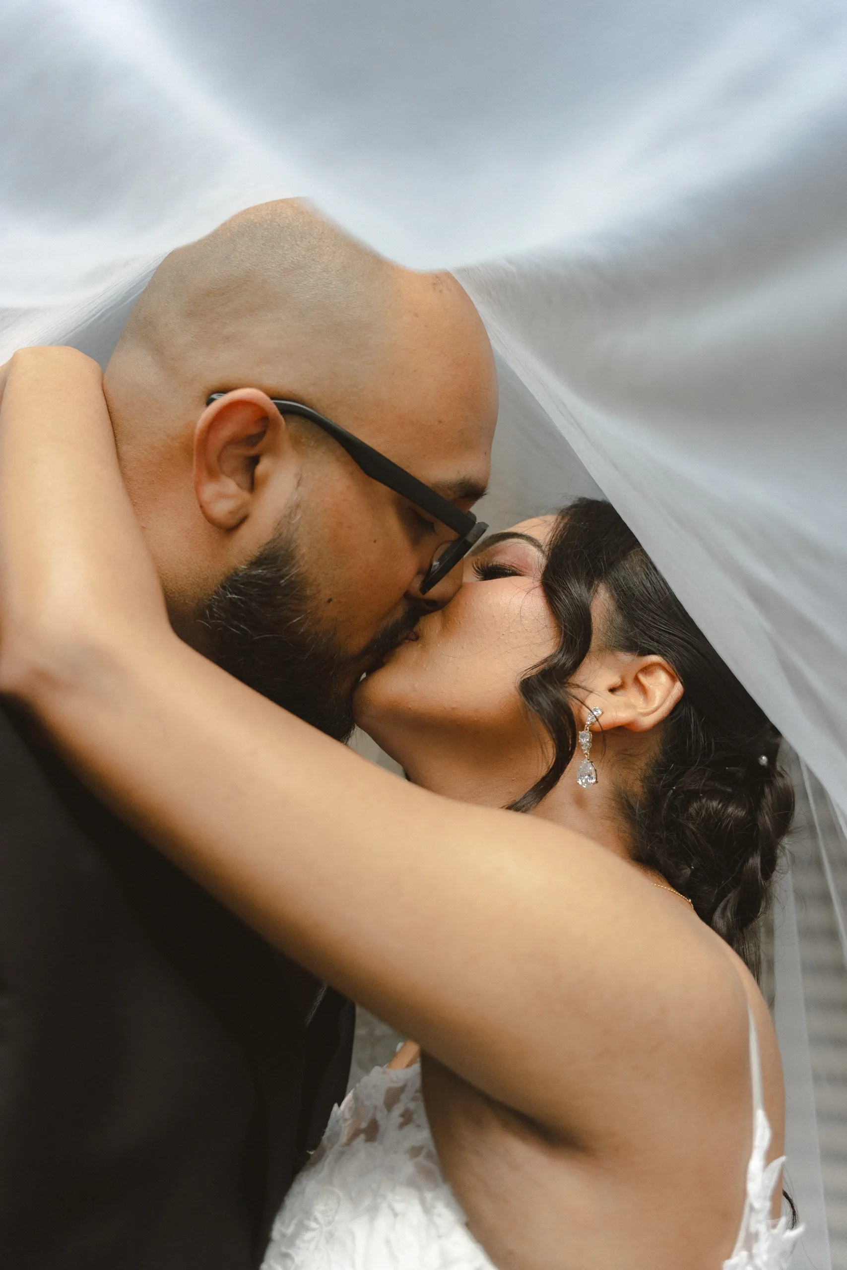 The couple kiss beneath the veil in the City Hall colonnade, by AD Photography
