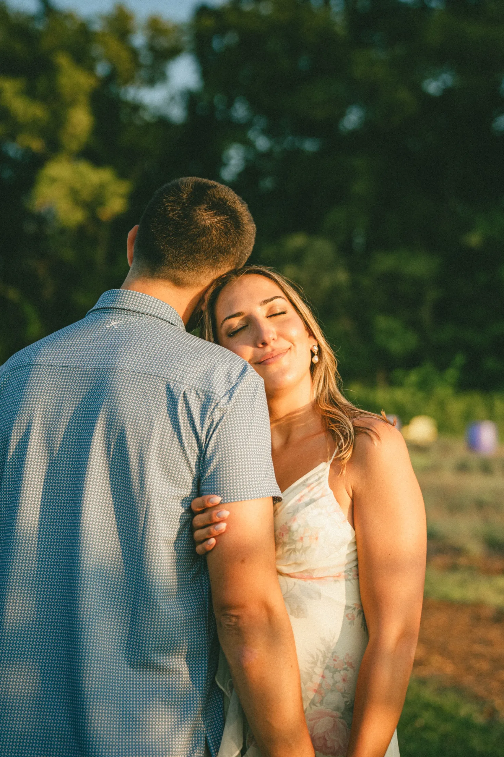 Ashley with her eyes closed and her cheek against Donald's shoulder at the edge of the lavender field, by AD Photography