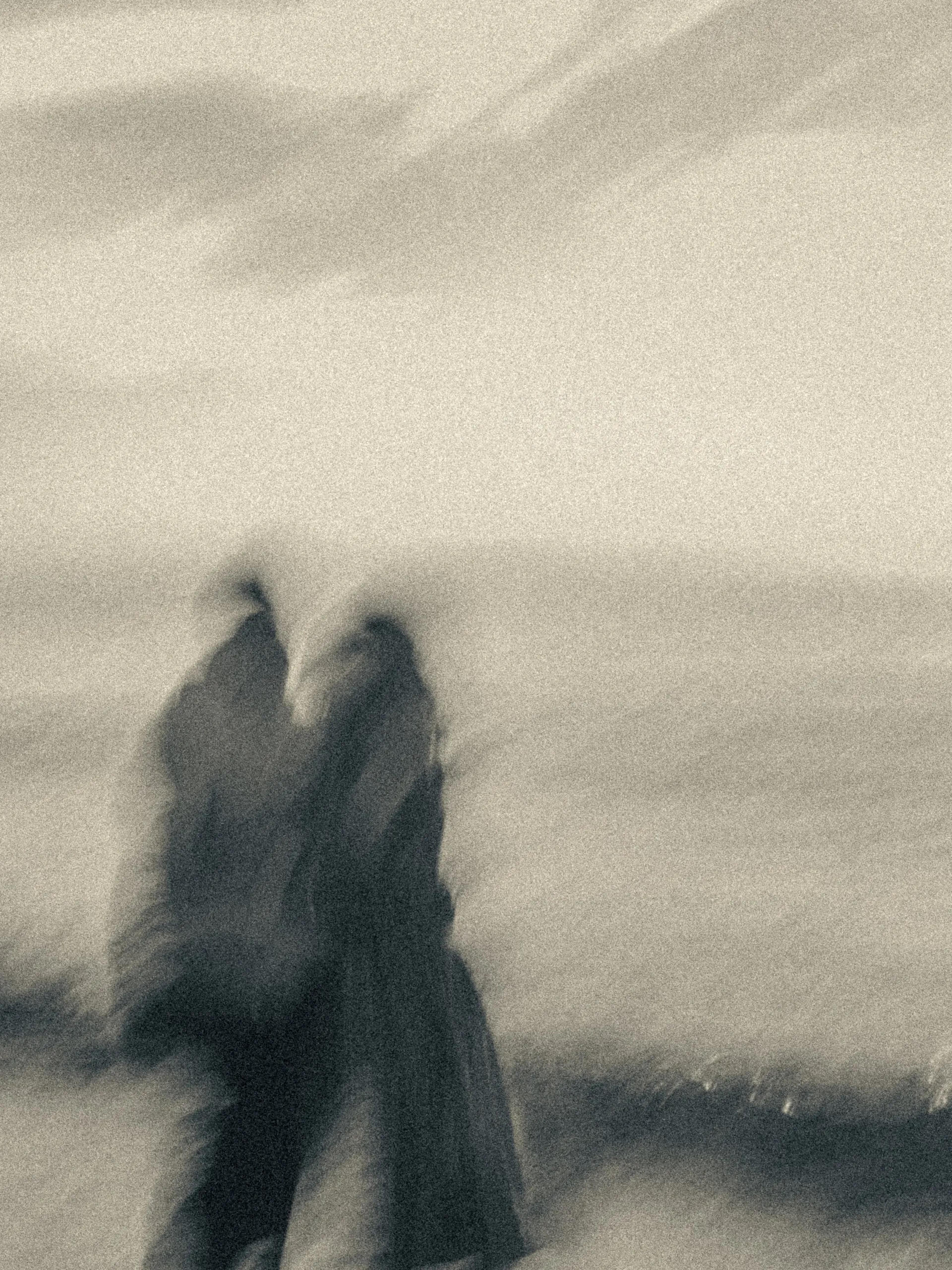 Monochrome blur reduces Maninder and Parneet to two dark shapes leaning their heads together by the water, by AD Photography