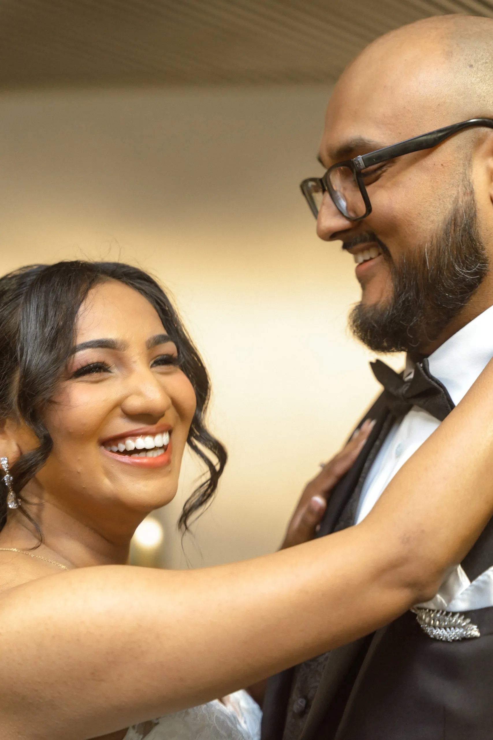 Bride laughs with her hands on the groom's chest inside City Hall, by AD Photography