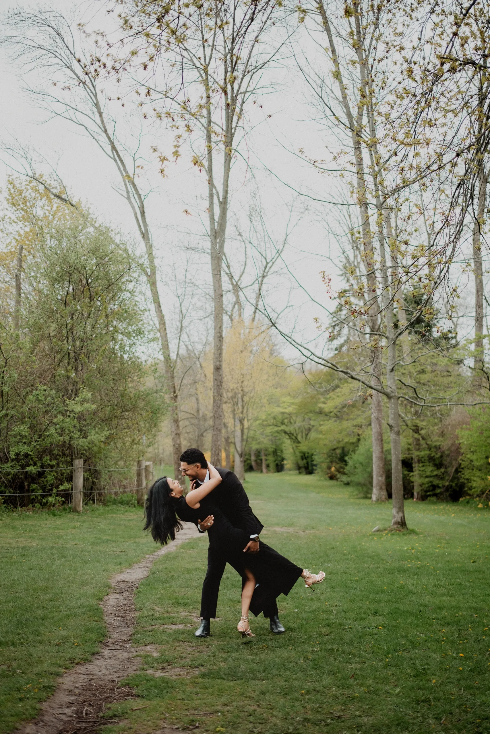 A dip on the tree lined path, the spring branches still bare above them, by AD Photography