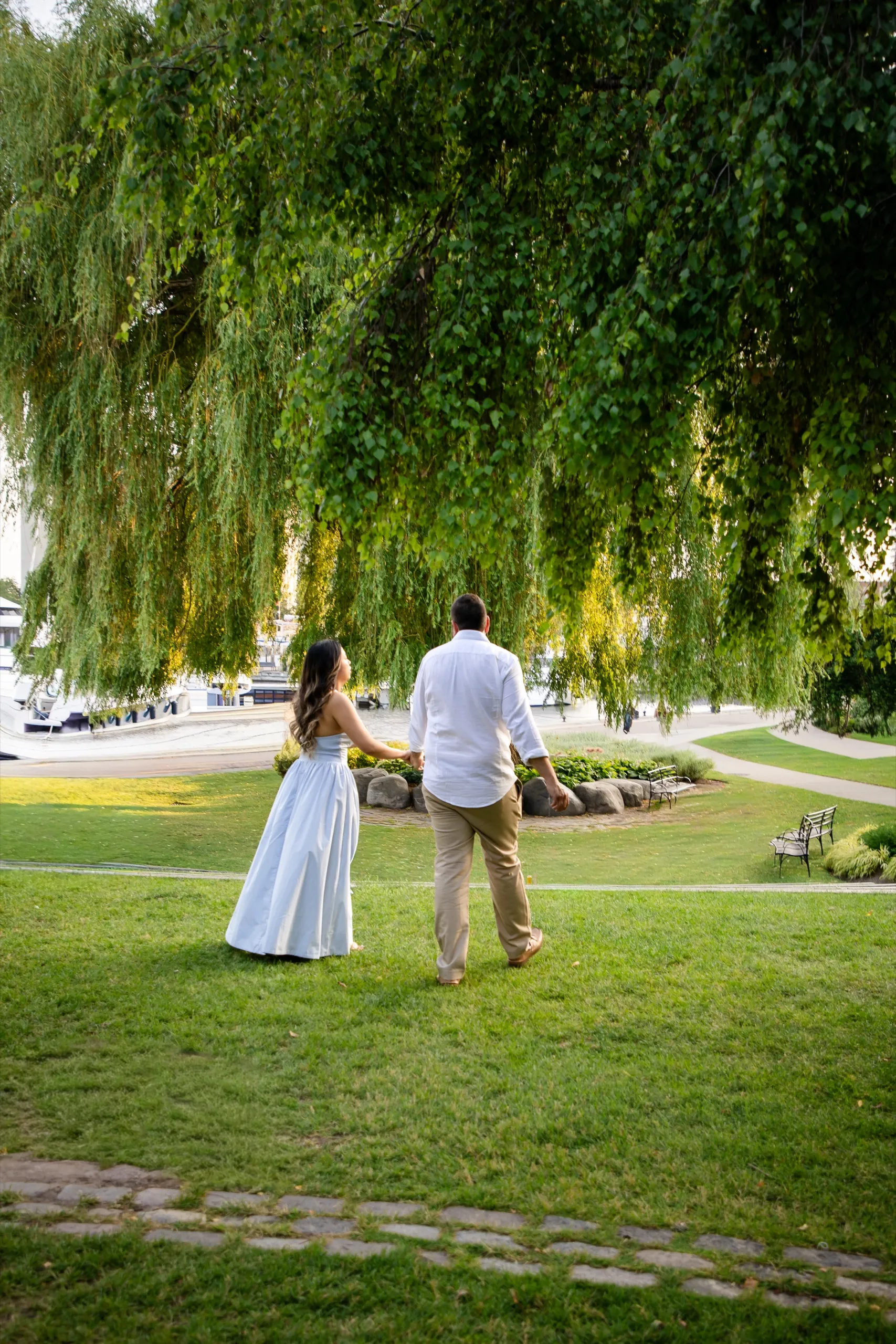Margarita and Mike walking under the weeping willow toward the marina at the Toronto Music Garden, by AD Photography