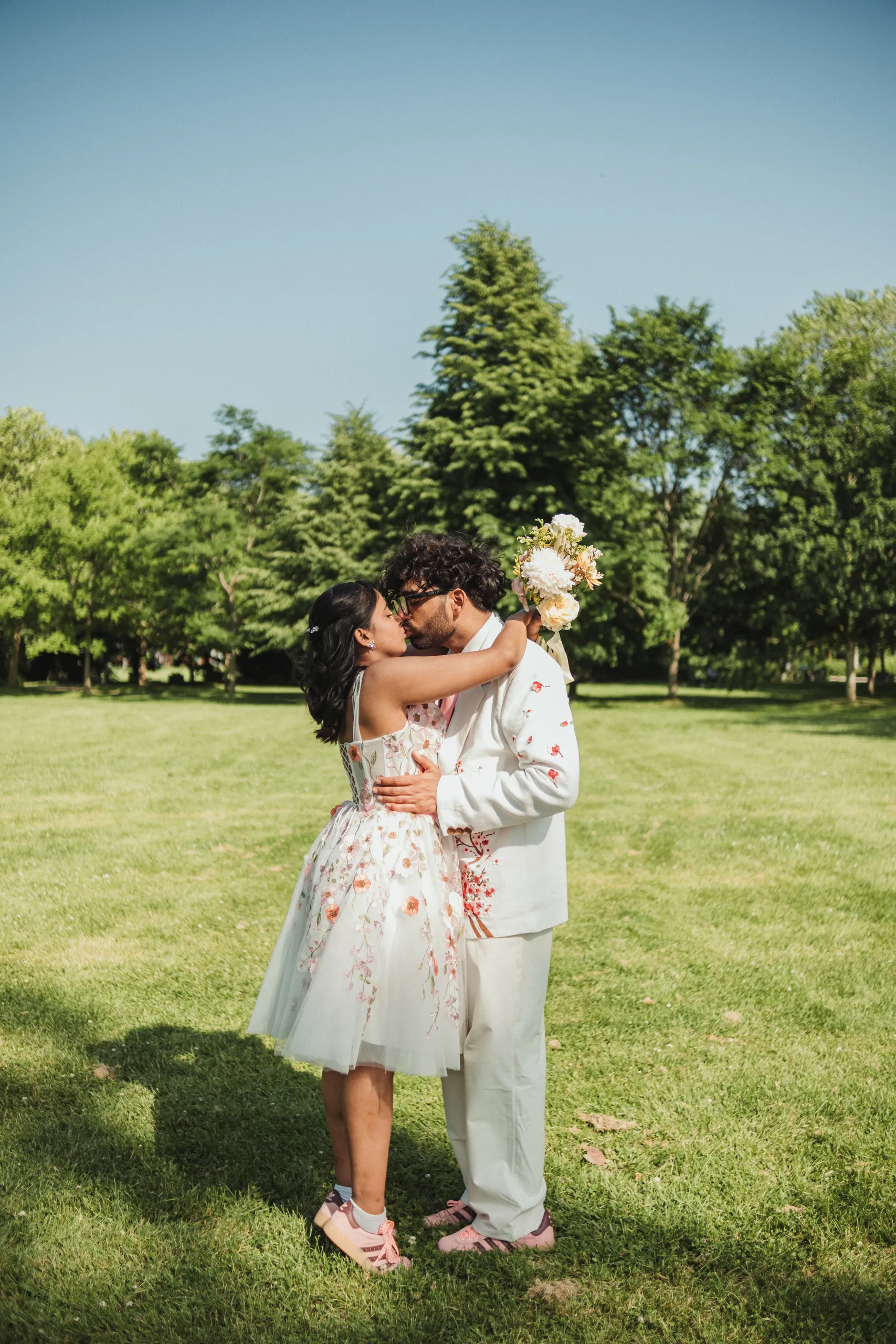 A ghosted slow shutter frame of Harsh and Payal kissing on the Toronto Islands lawn, by AD Photography